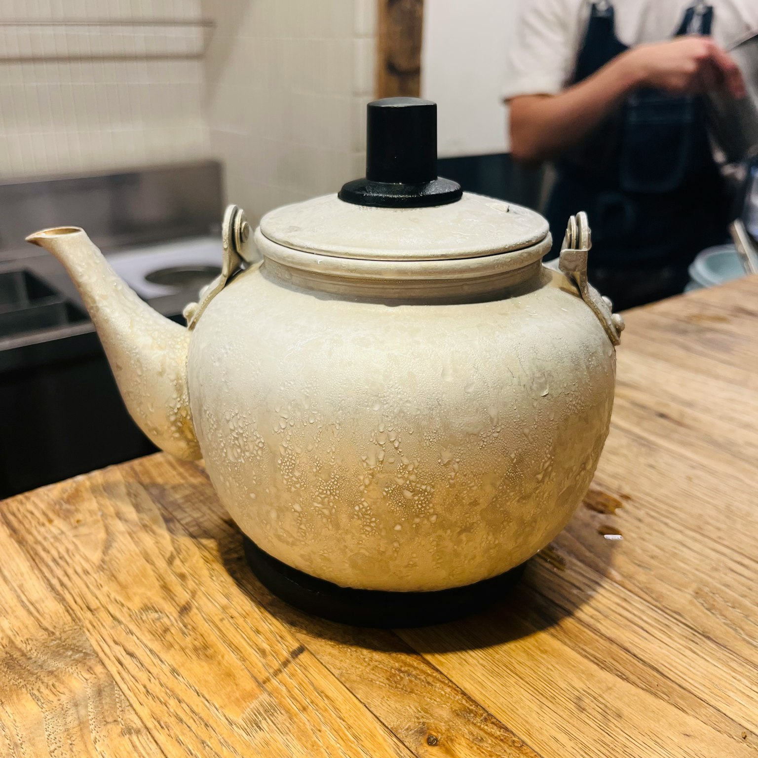 An old ceramic teapot placed on a wooden table