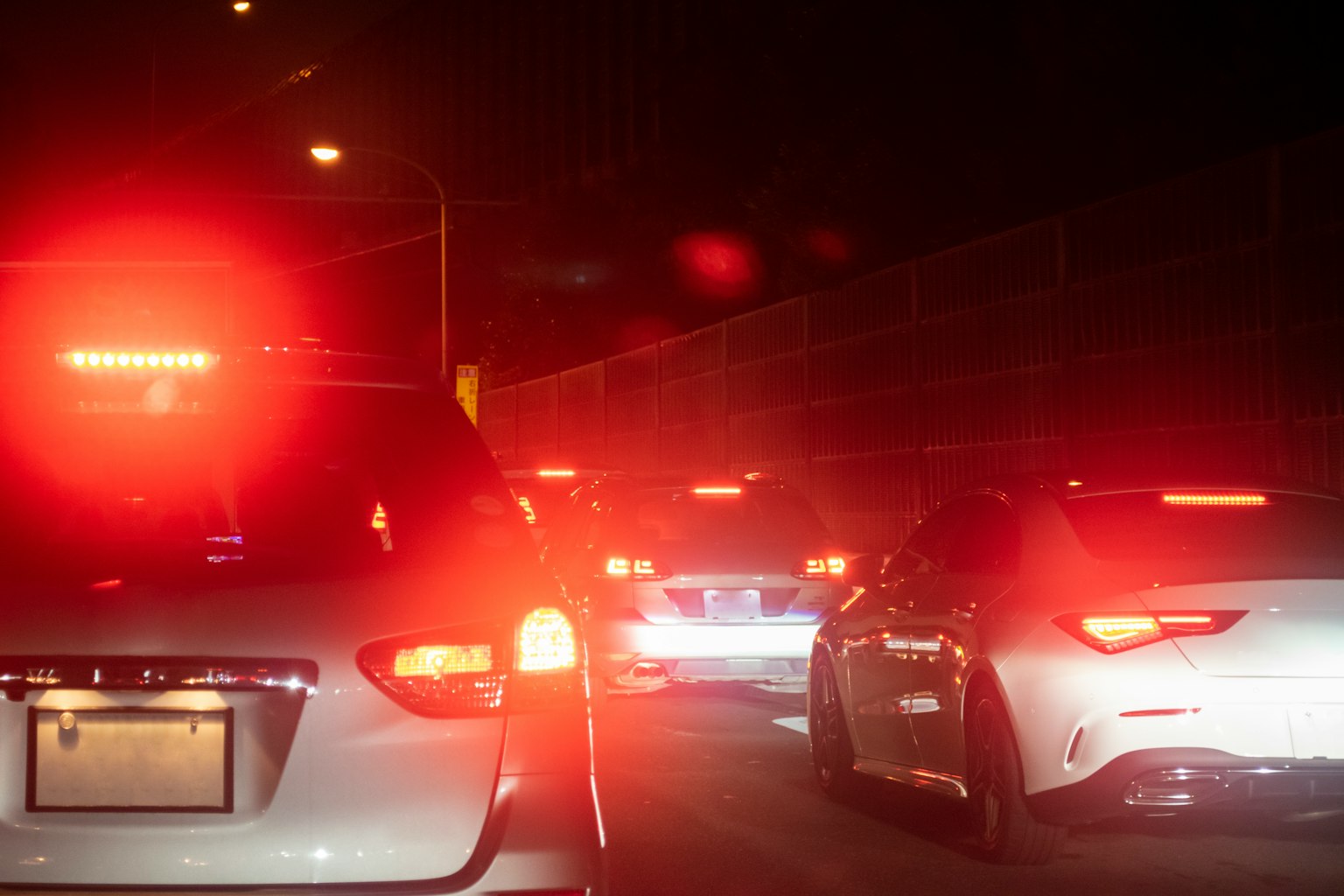 Deretan kendaraan dalam kemacetan malam dengan lampu belakang merah