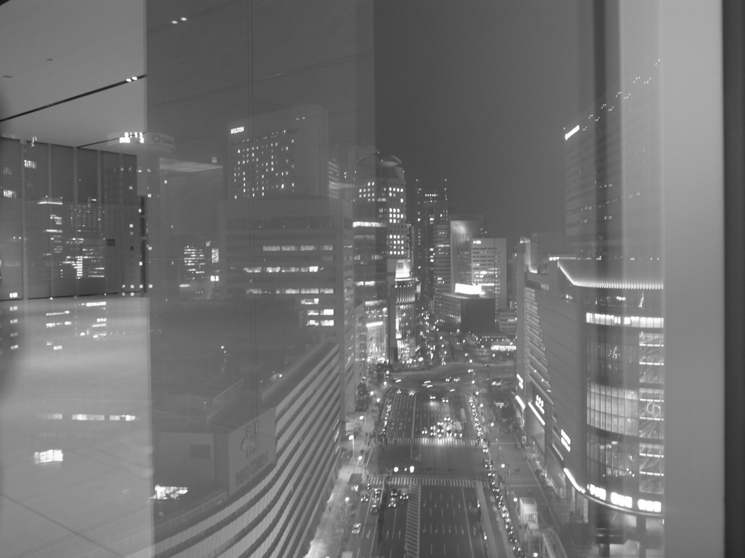 Vista notturna della città attraverso una finestra con riflessi