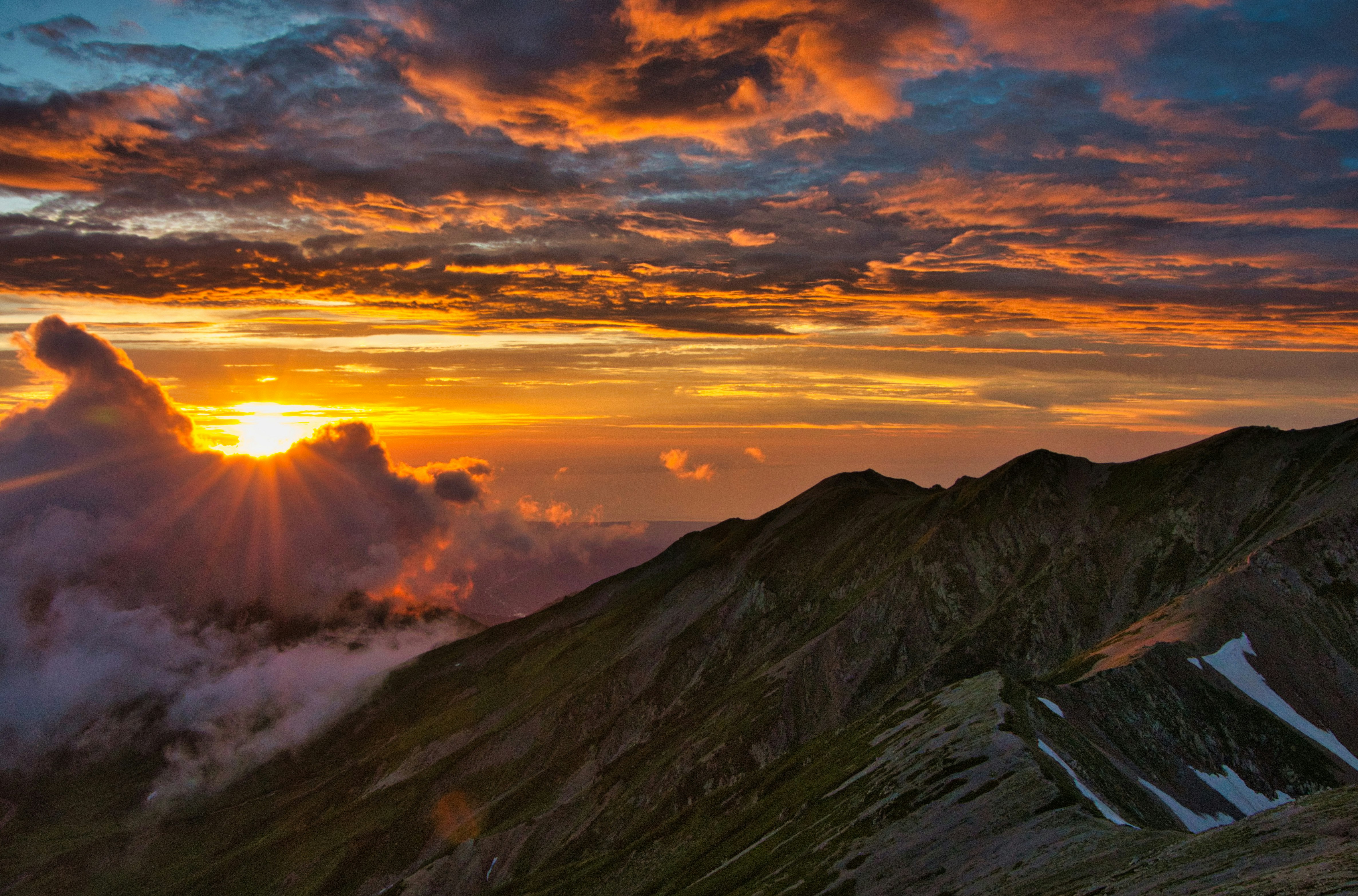 嵐の後の雲海と立山連峰の夕日が差す稜線の風景