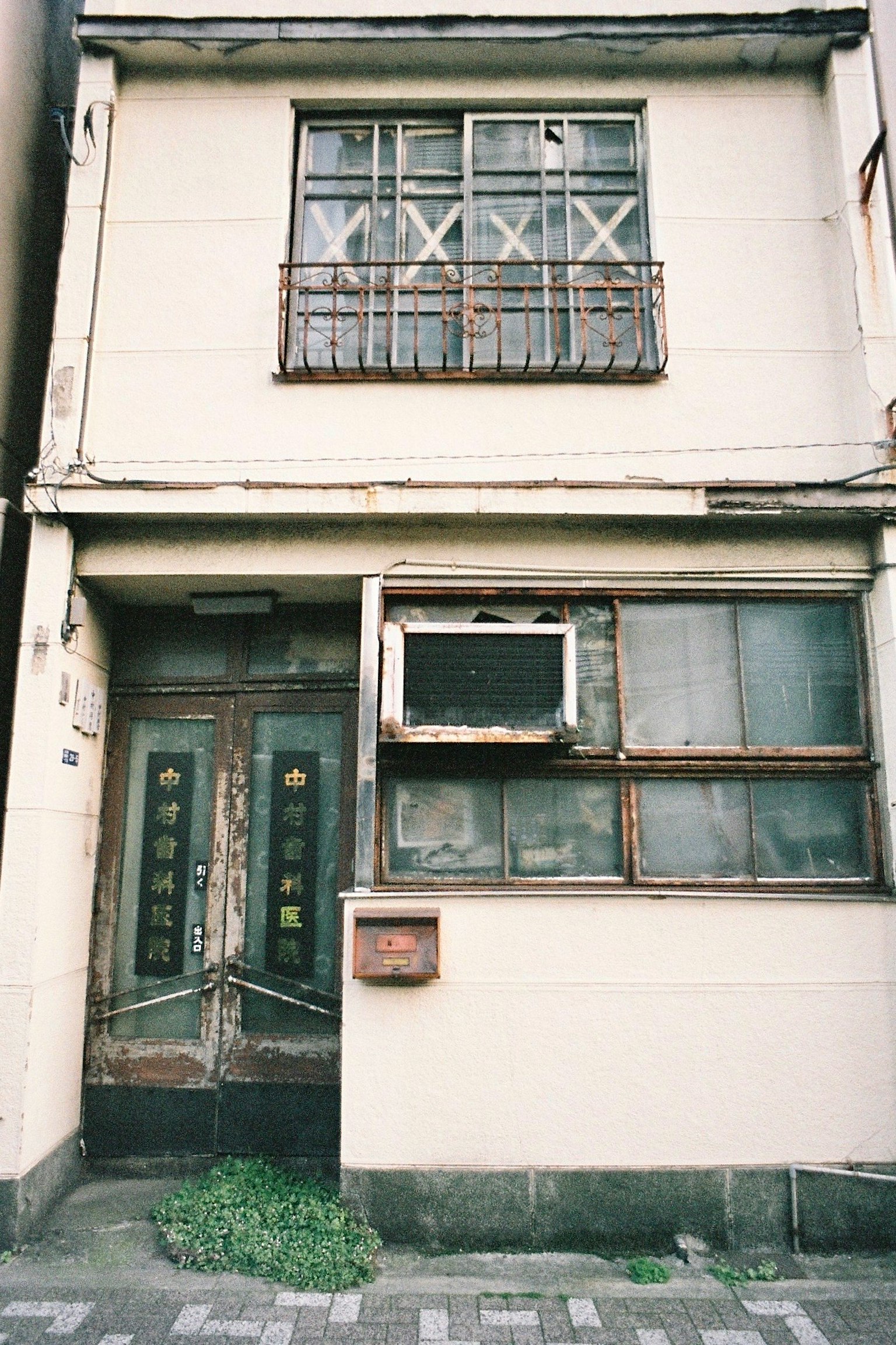 Extérieur d'une vieille maison avec des fenêtres cassées et des portes ornées