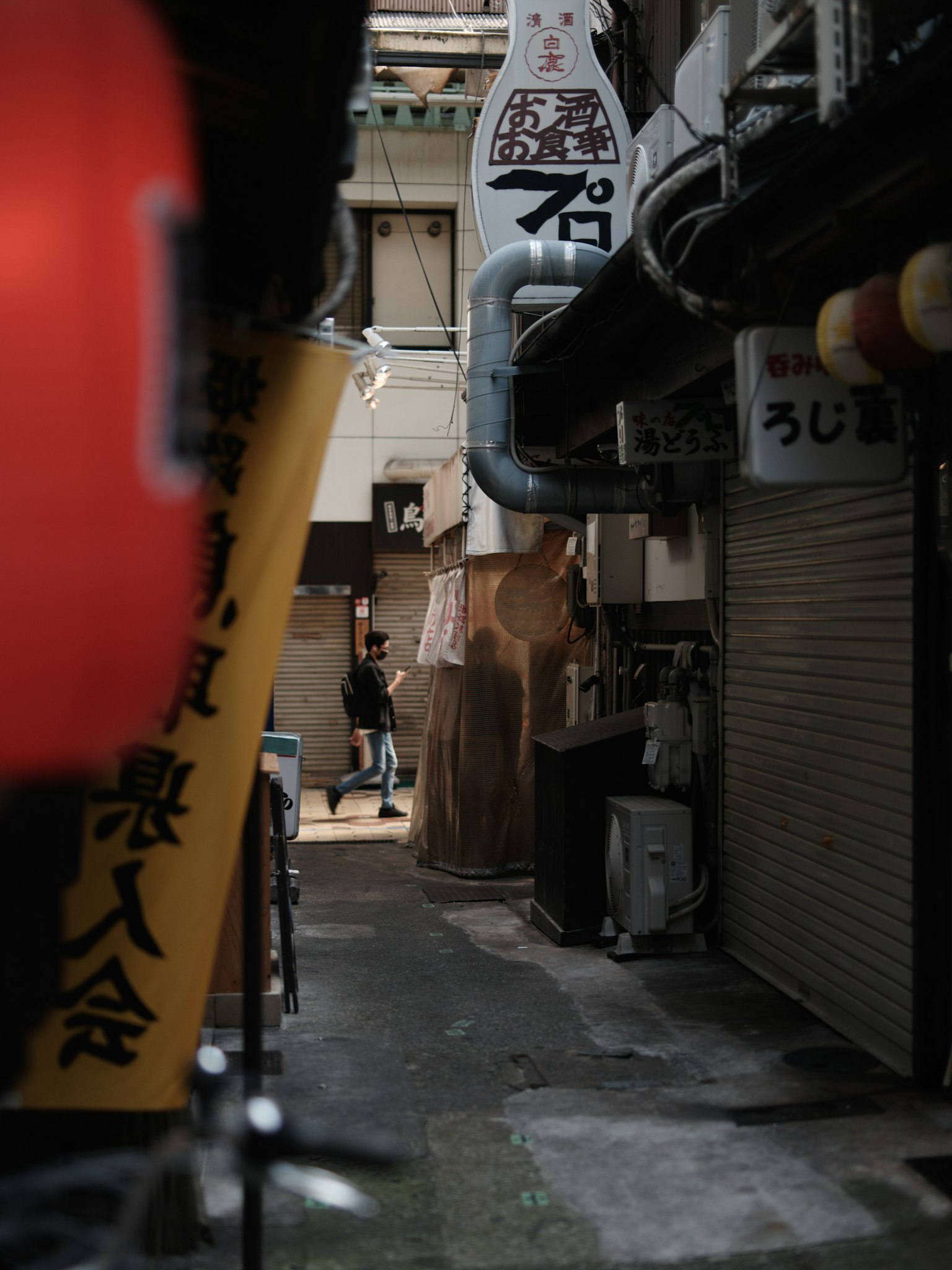 Callejón estrecho con letreros de restaurantes y ambiente tenue