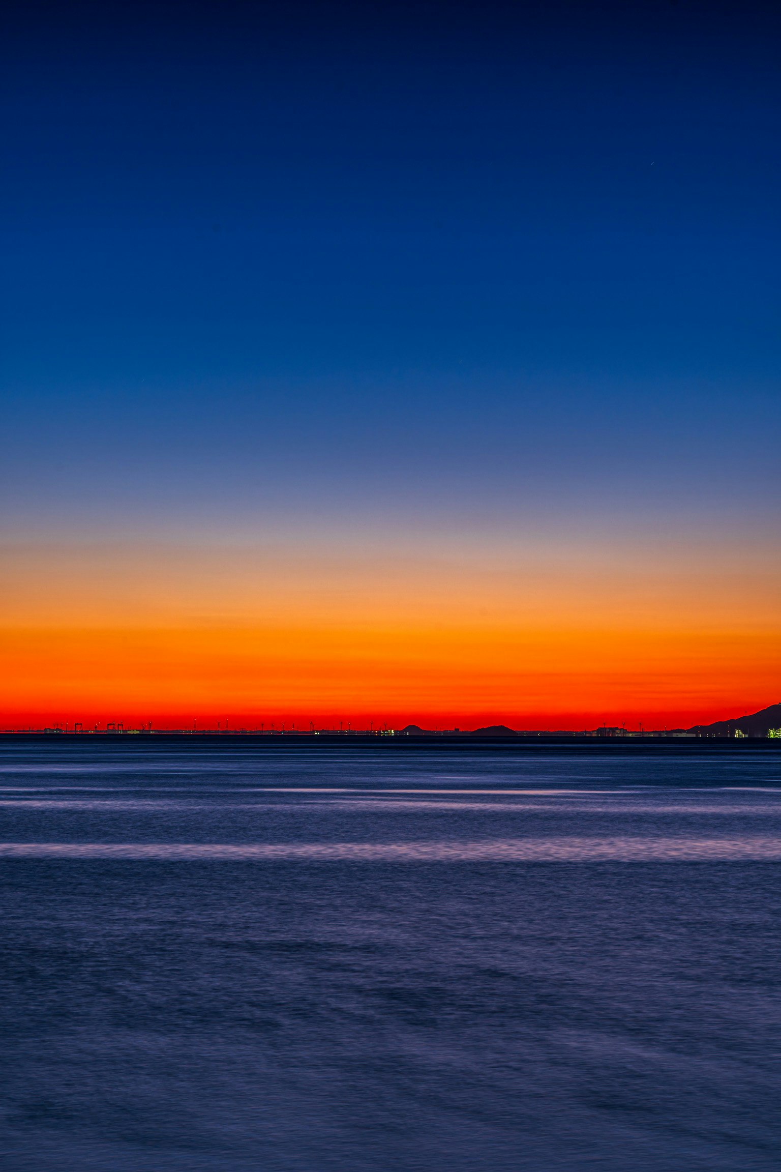 Stunning sunset over the ocean with gradient from blue to orange