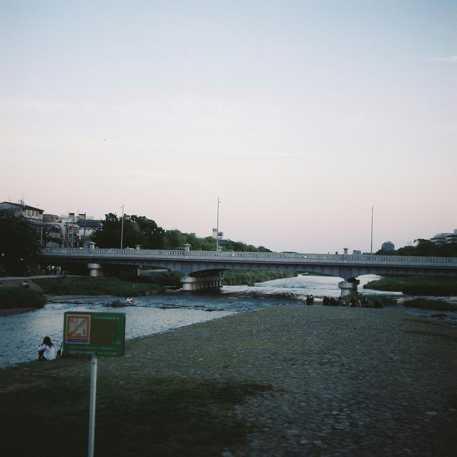Vista di un ponte su un fiume calmo al crepuscolo