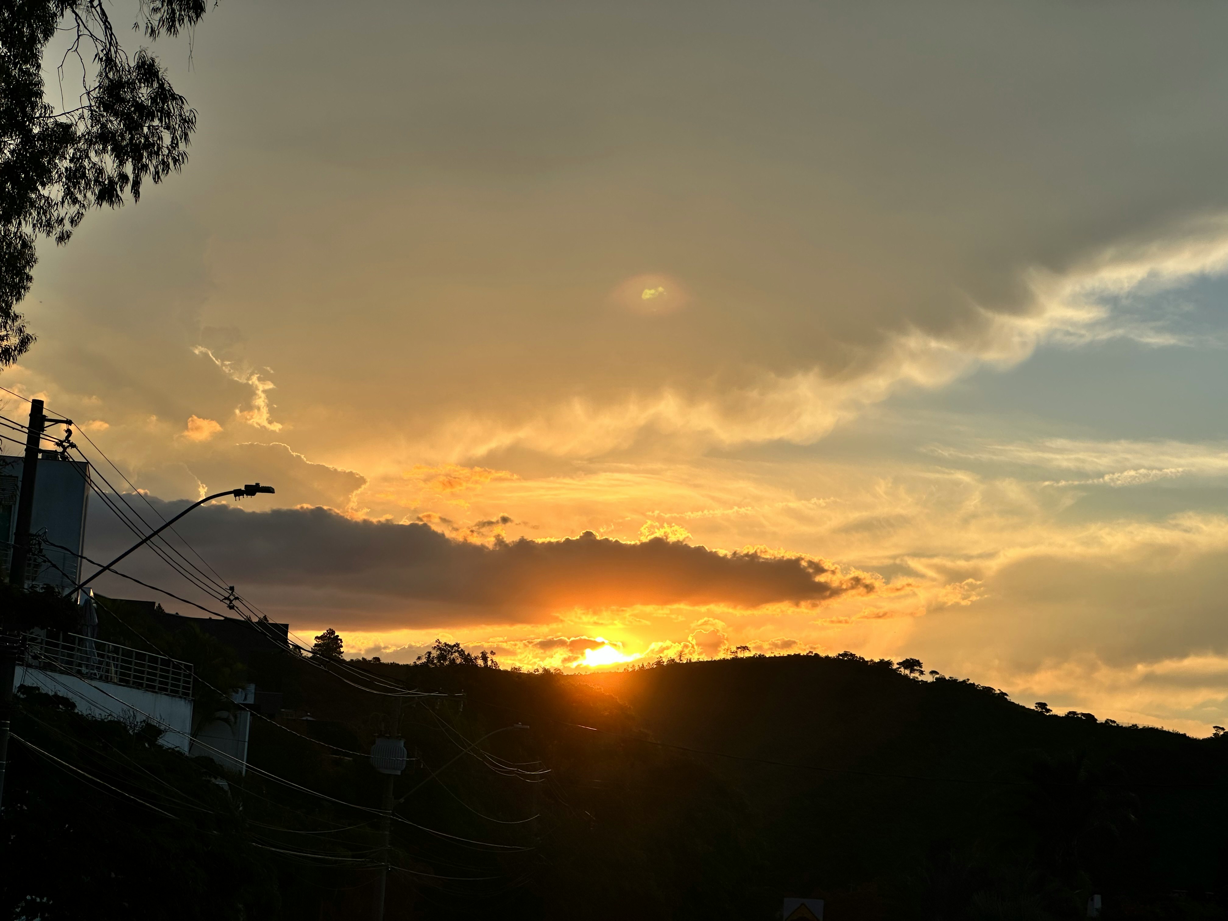 夕日に照らされる丘陵の稜線と雲の空