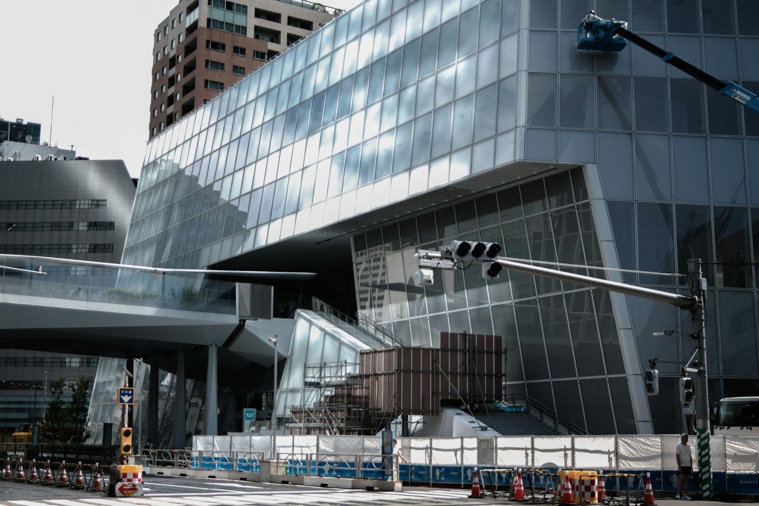 Mặt tiền của tòa nhà kính hiện đại với khu vực xây dựng nhìn thấy được