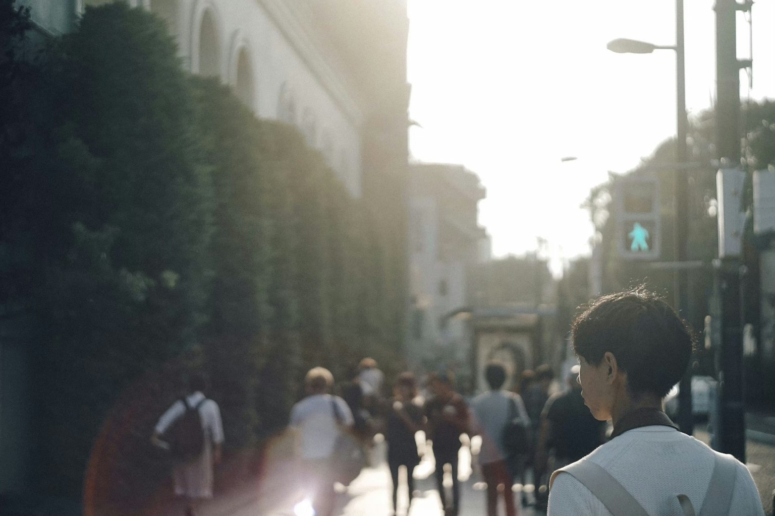 Persone che camminano in città al tramonto con una luce calda