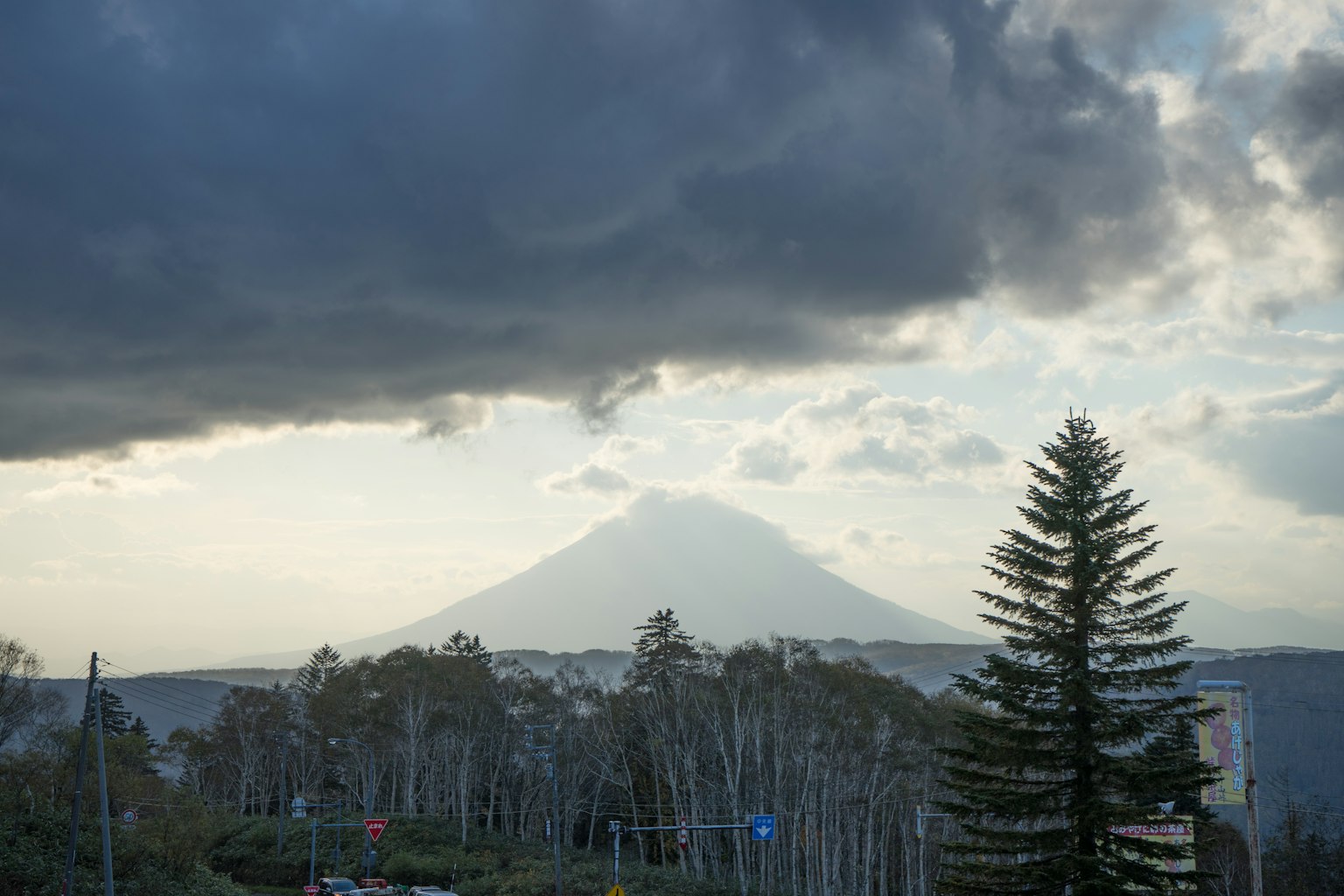 Una vista escénica de una montaña rodeada de nubes y árboles