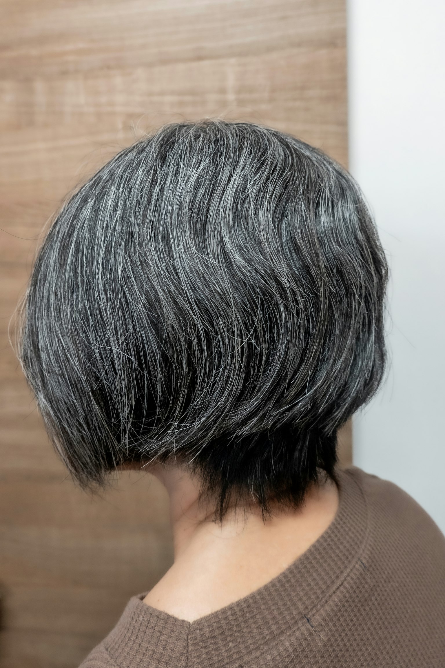 Vue de dos d'une femme avec une coiffure bob grise