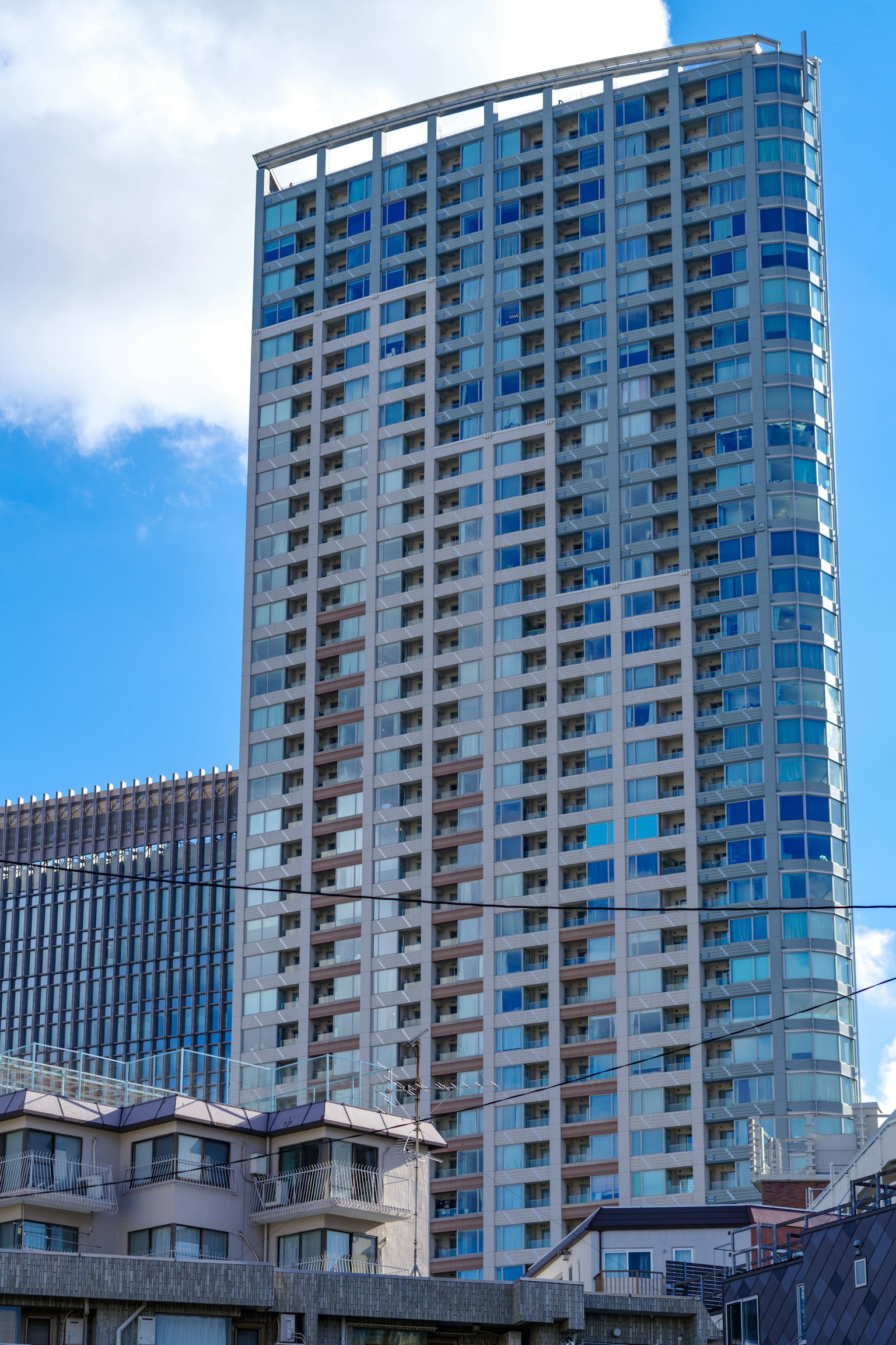 Exterior de un edificio moderno de gran altura bajo un cielo azul