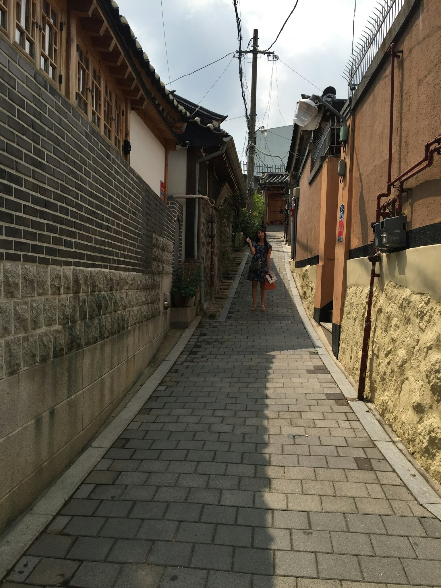 Allée étroite pavée de pierres avec des maisons coréennes traditionnelles et une pente