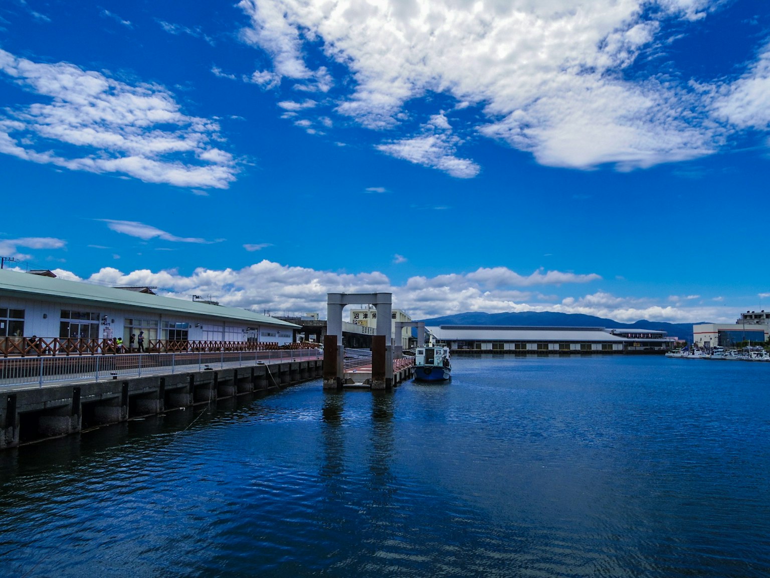 Vue pittoresque sur le waterfront avec un ciel bleu et des nuages et un quai avec des bateaux