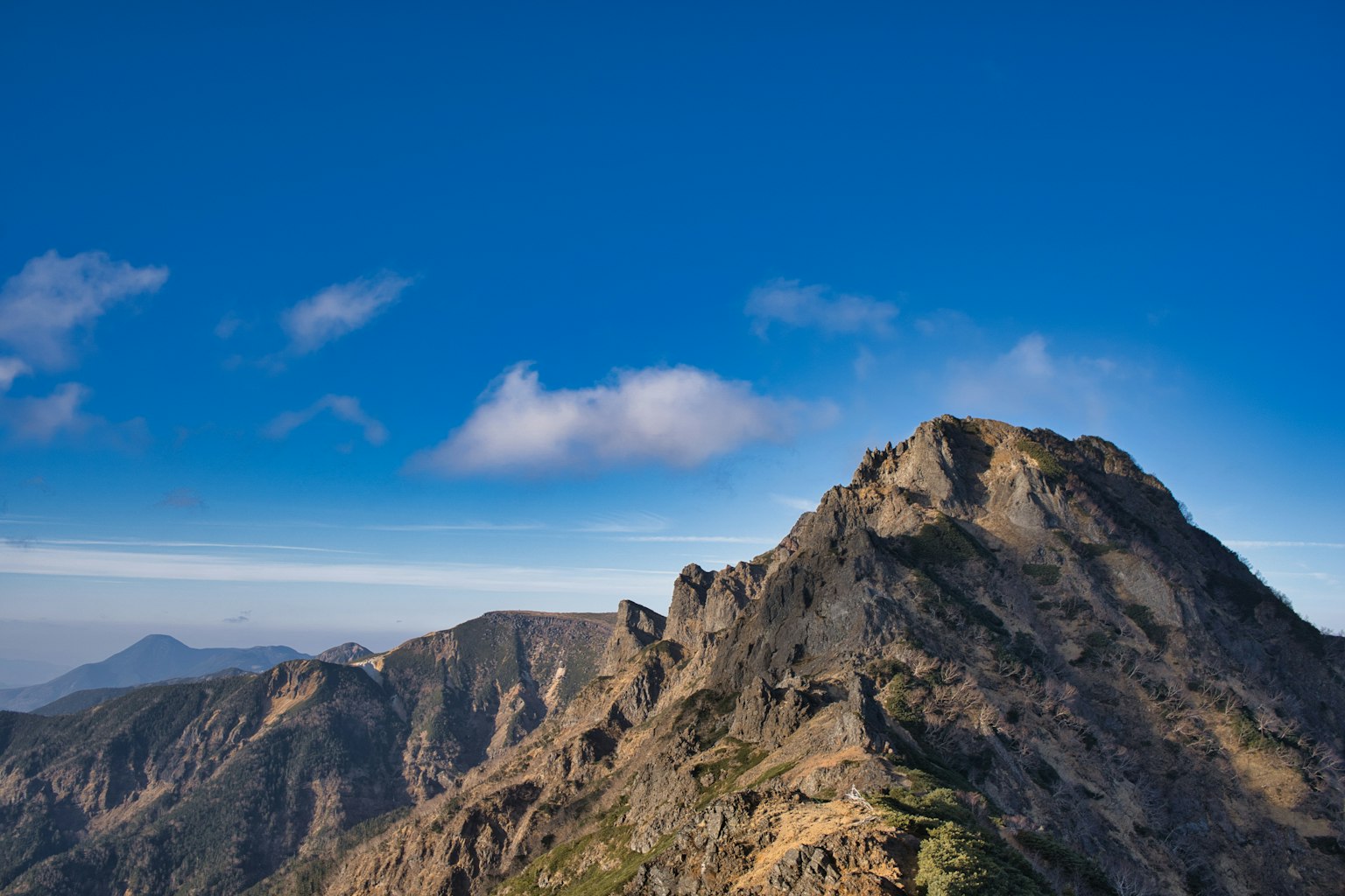 Pemandangan gunung dengan latar belakang langit biru dan awan