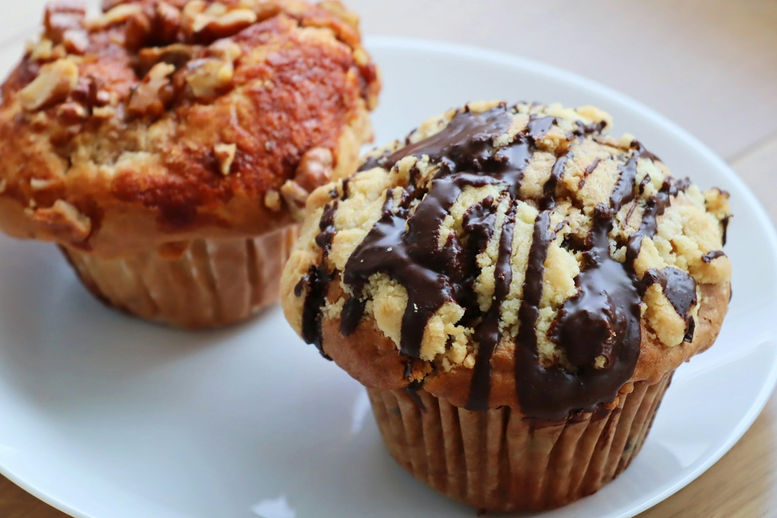 Due muffin su un piatto, uno con noci e l'altro con cioccolato