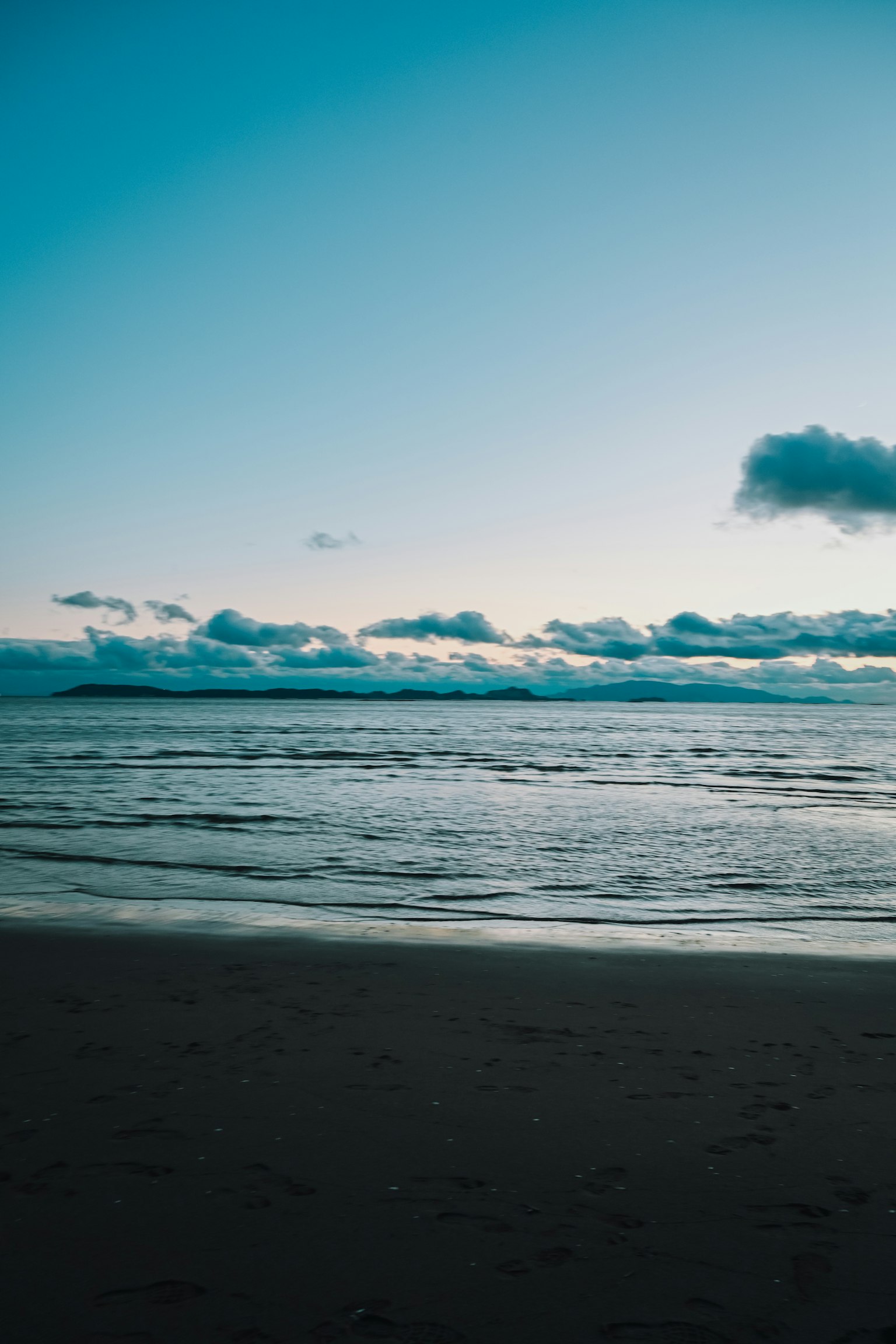 Paesaggio marino sereno con oceano calmo e cielo blu con nuvole soffici