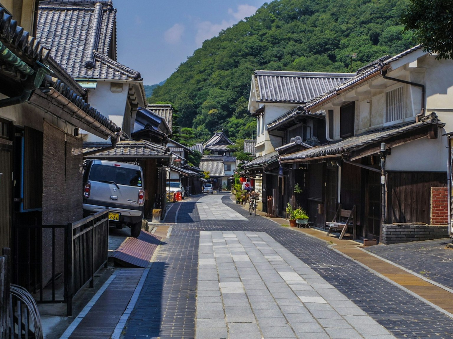 Escena de calle japonesa tradicional con fondo montañoso