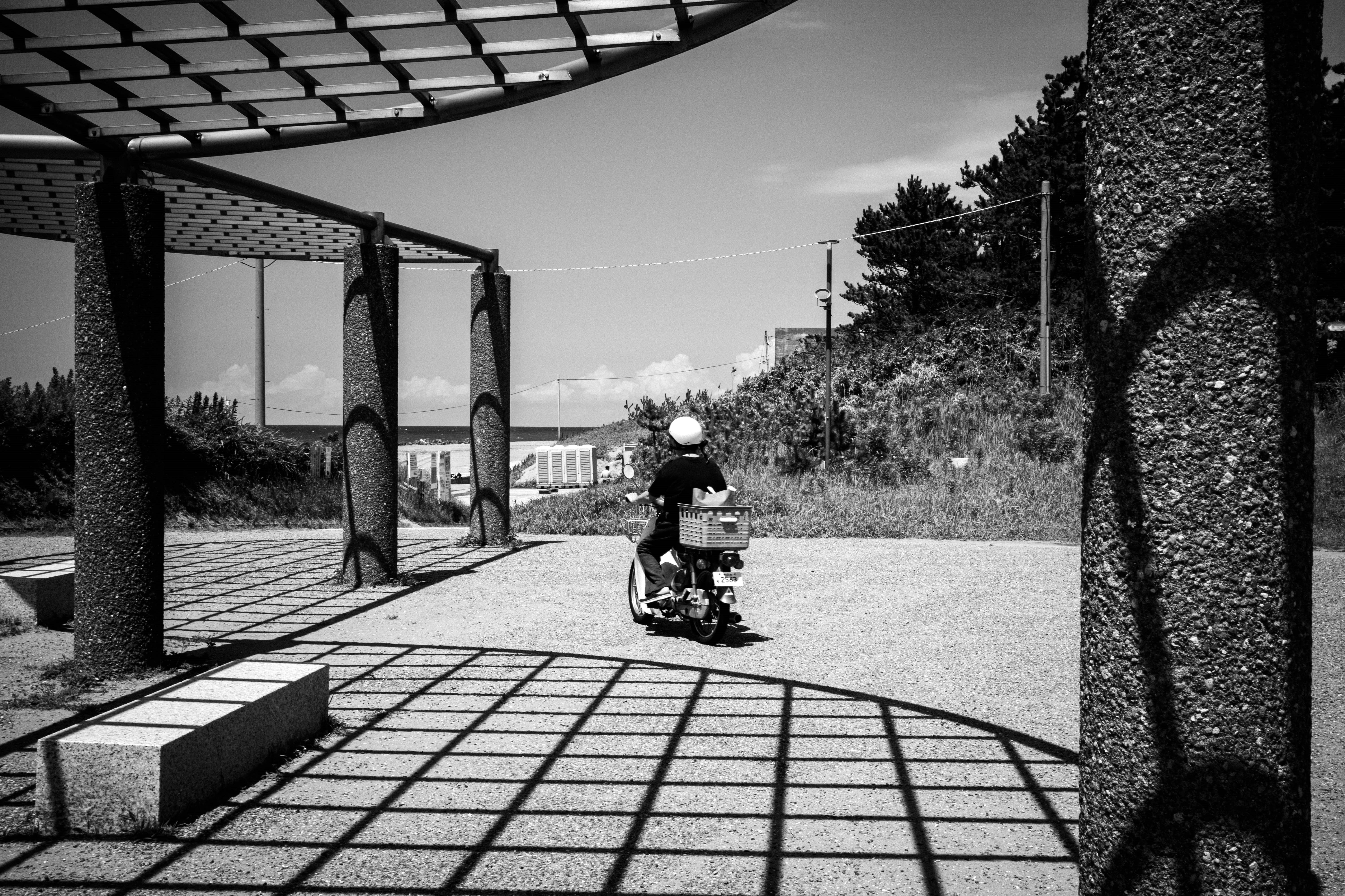 A child riding on a scooter along a tiled outdoor walkway