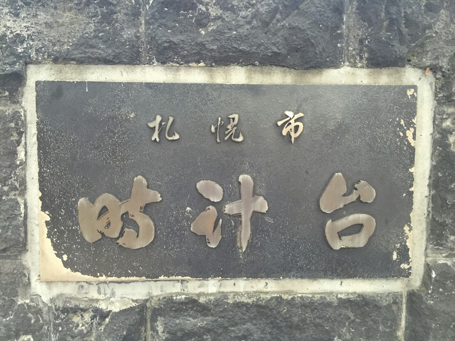 Schild des Sapporo Clock Tower mit Inschriften