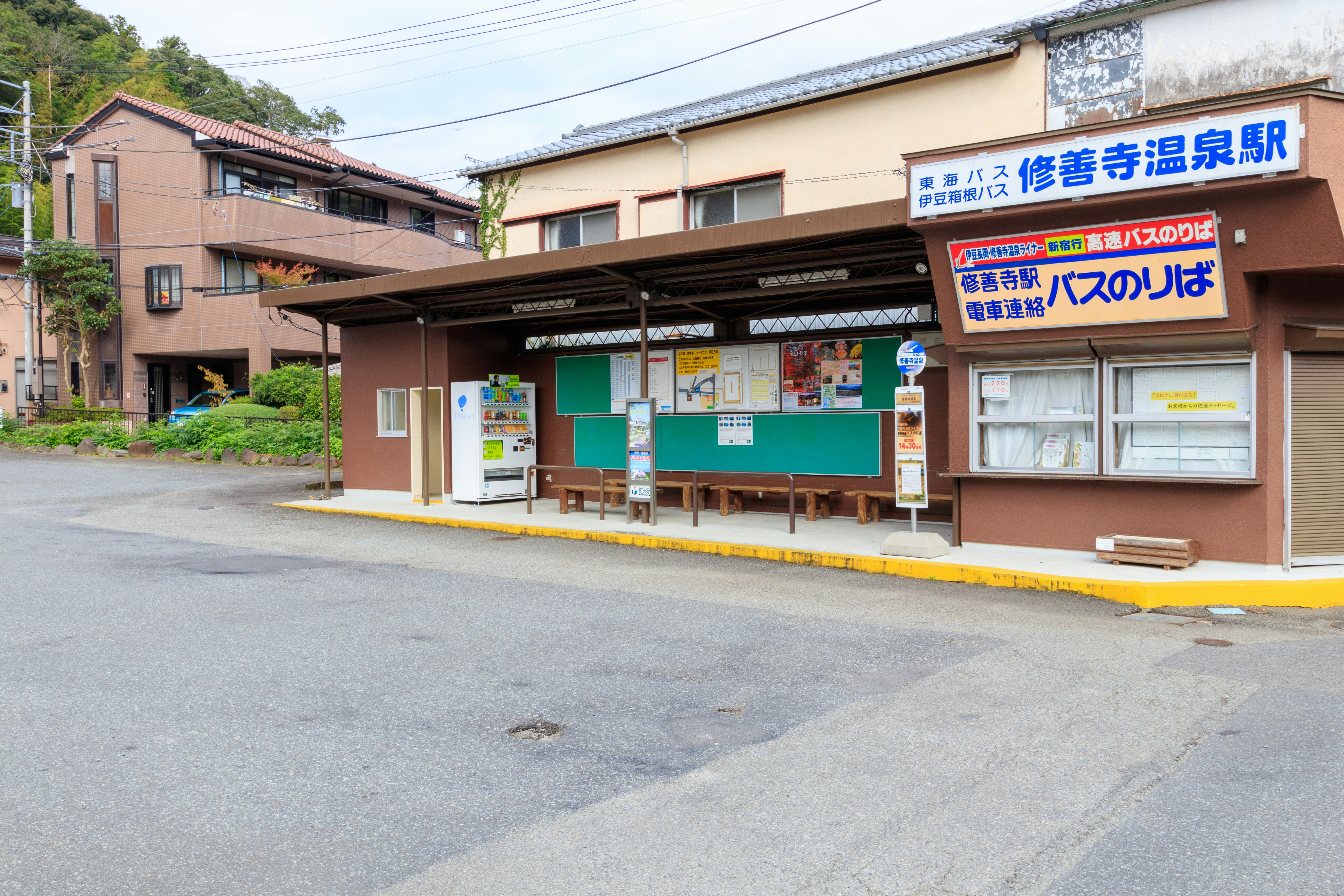 exterior of a hot spring facility with a waiting area and bulletin boards