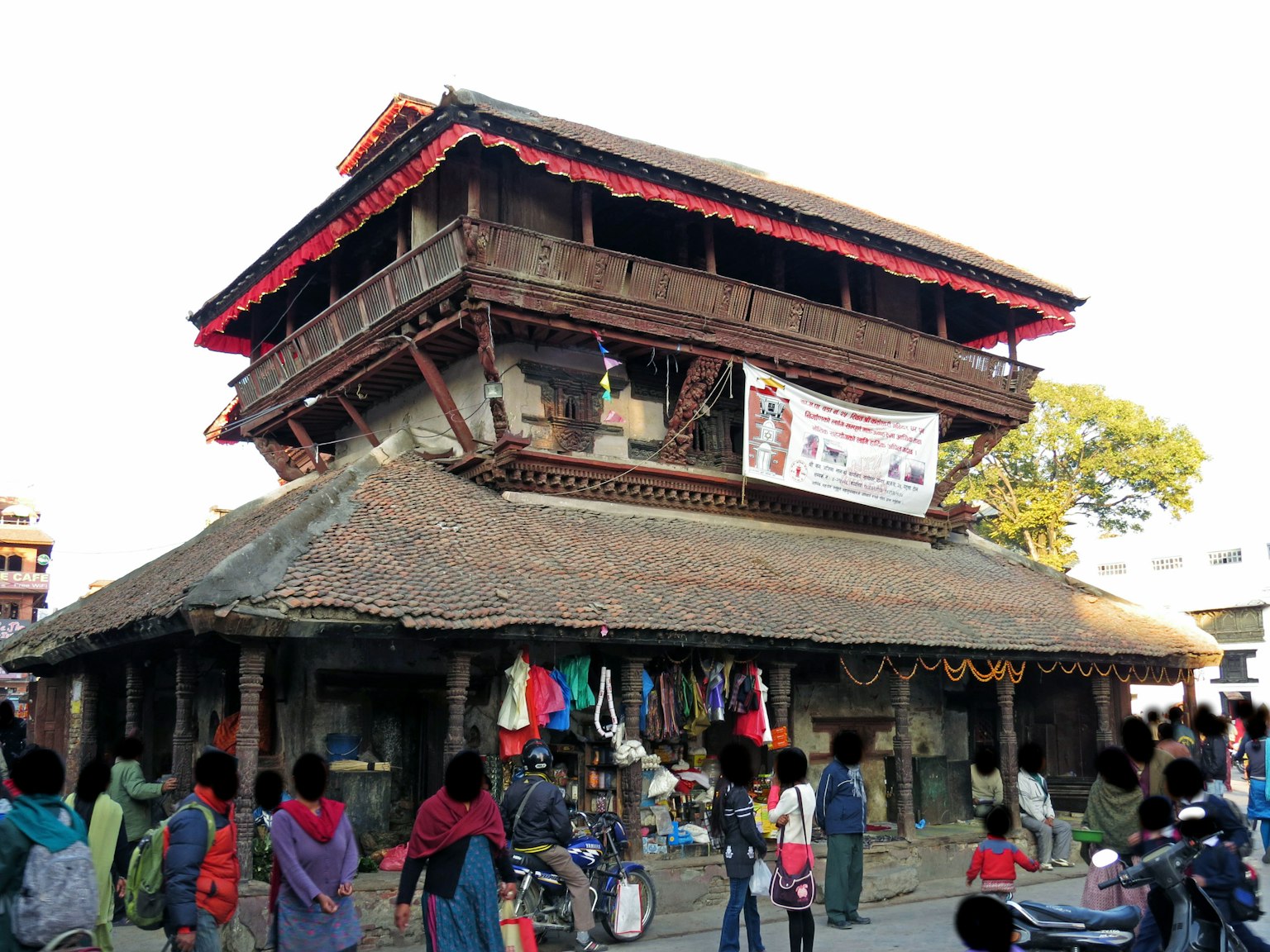Un bâtiment en bois historique avec un toit de chaume et des magasins le long de la rue