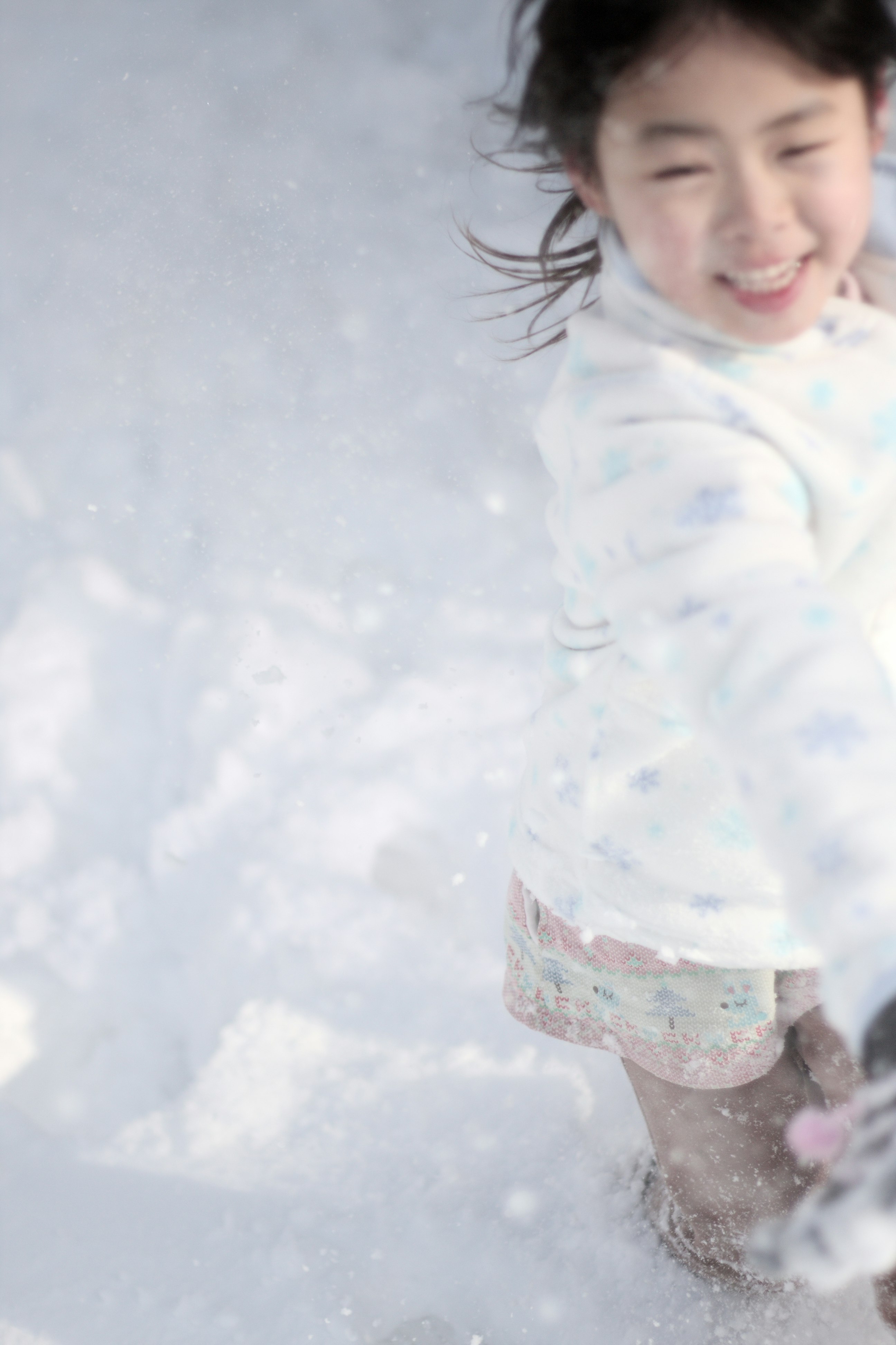 雪の中で笑顔の子どもが走る冬の風景
