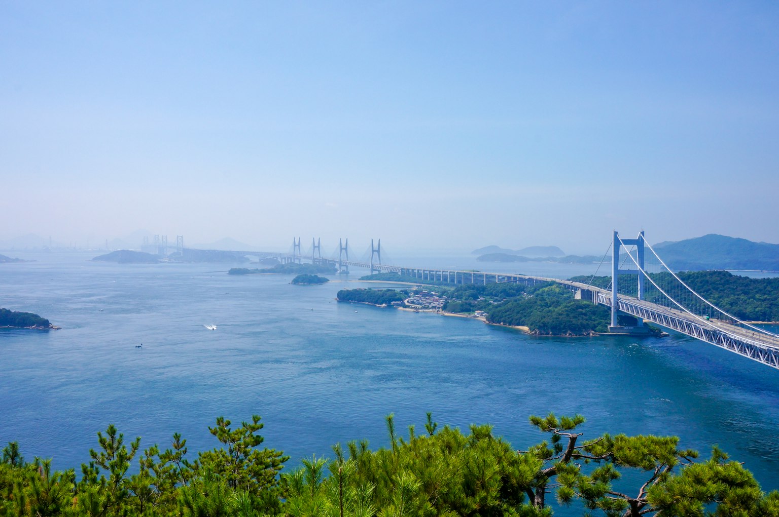 Vista escénica del mar azul con un puente y islas al fondo