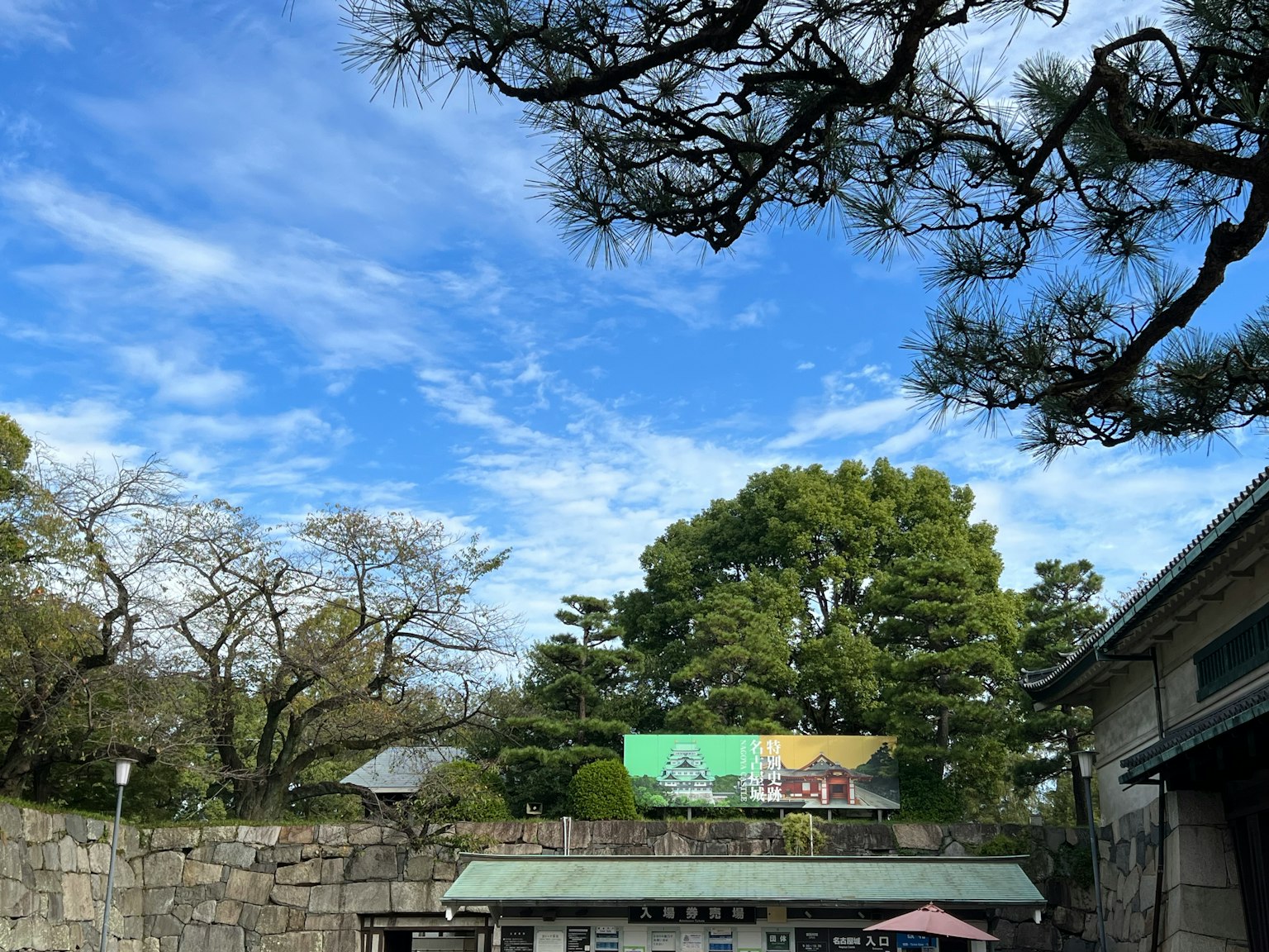 Scenic view with blue sky and green trees part of a walled garden