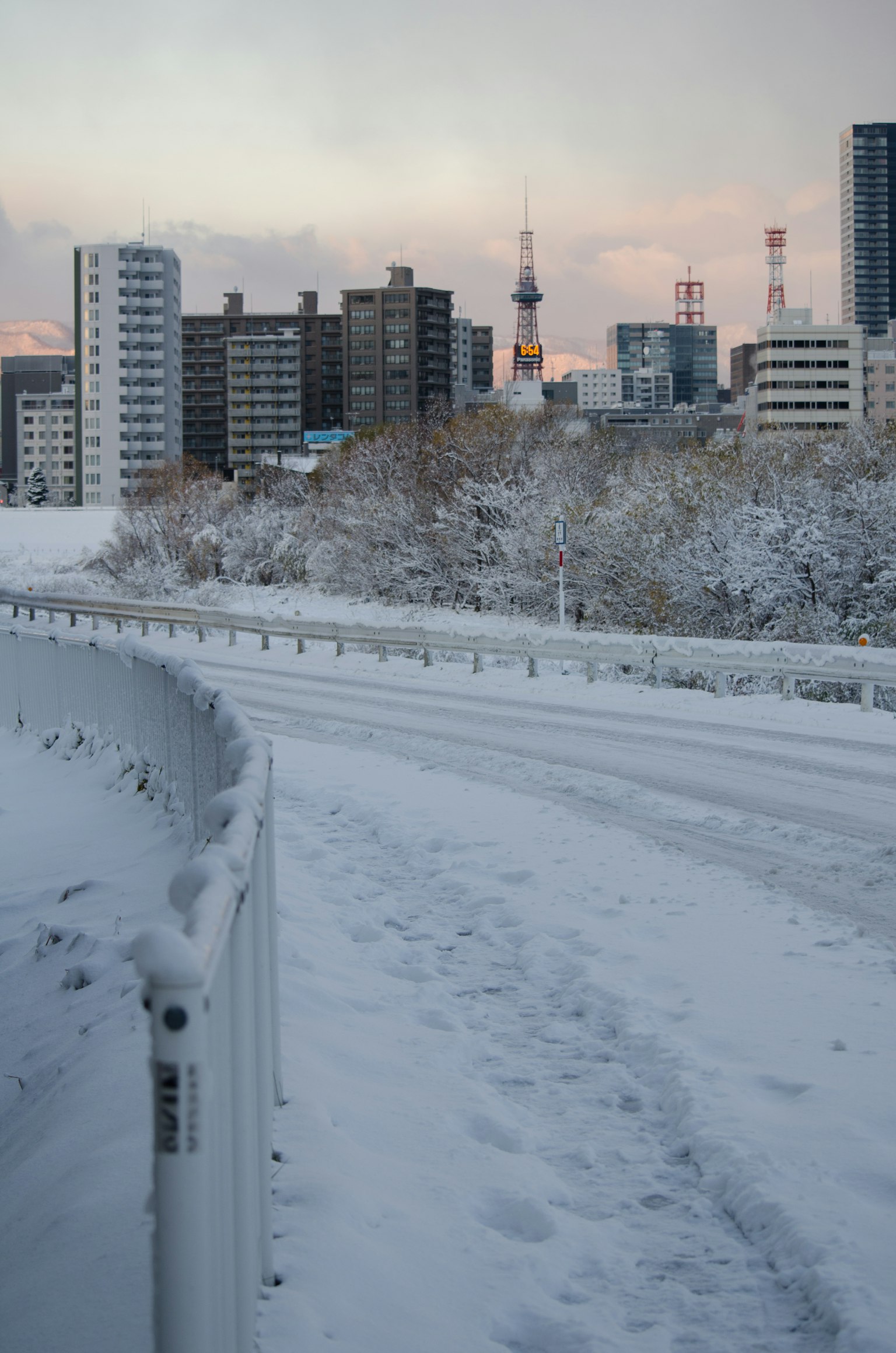 被雪覆盖的道路和背景中的建筑物在黄昏时分