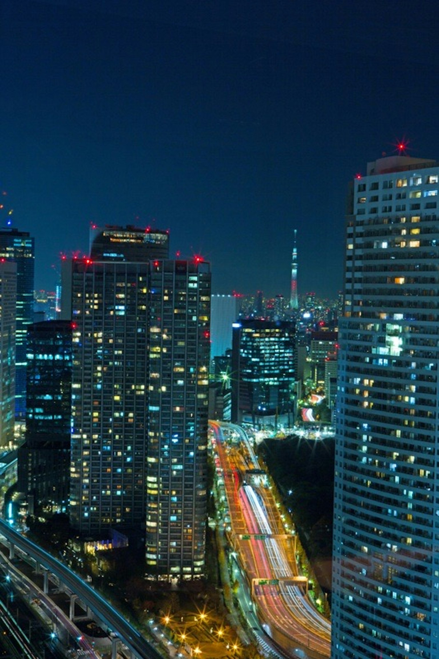 Pemandangan malam garis langit Tokyo dengan lampu mobil yang mengalir