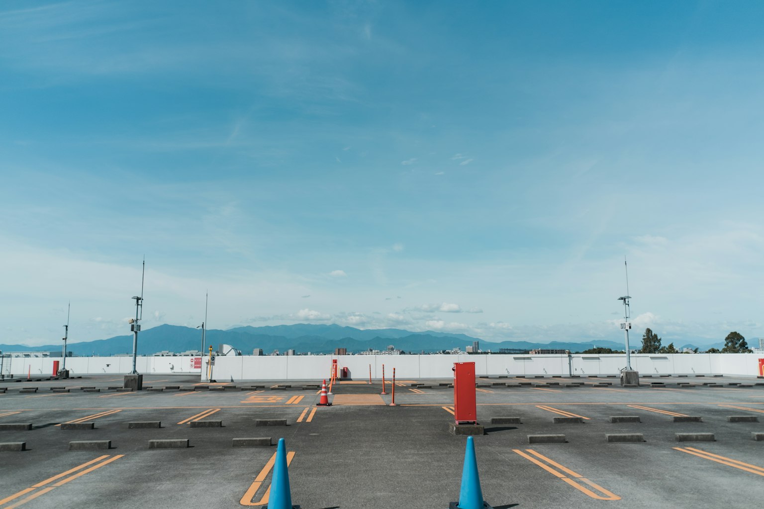 Parkplatz mit blauem Himmel und fernen Bergen