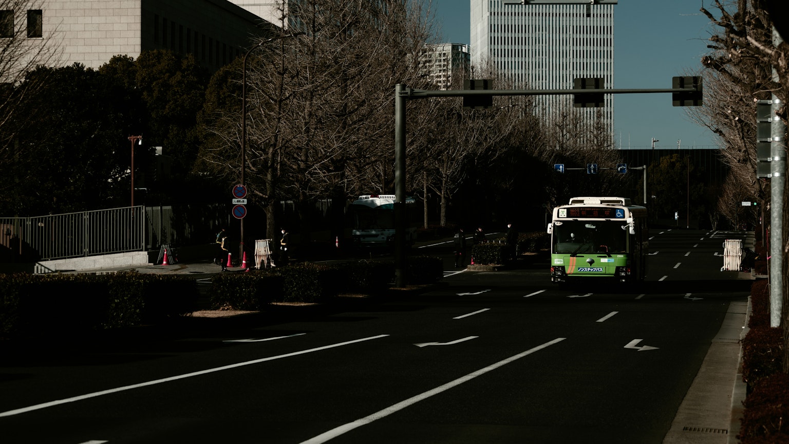 城市街道上的绿色公交车和其他车辆