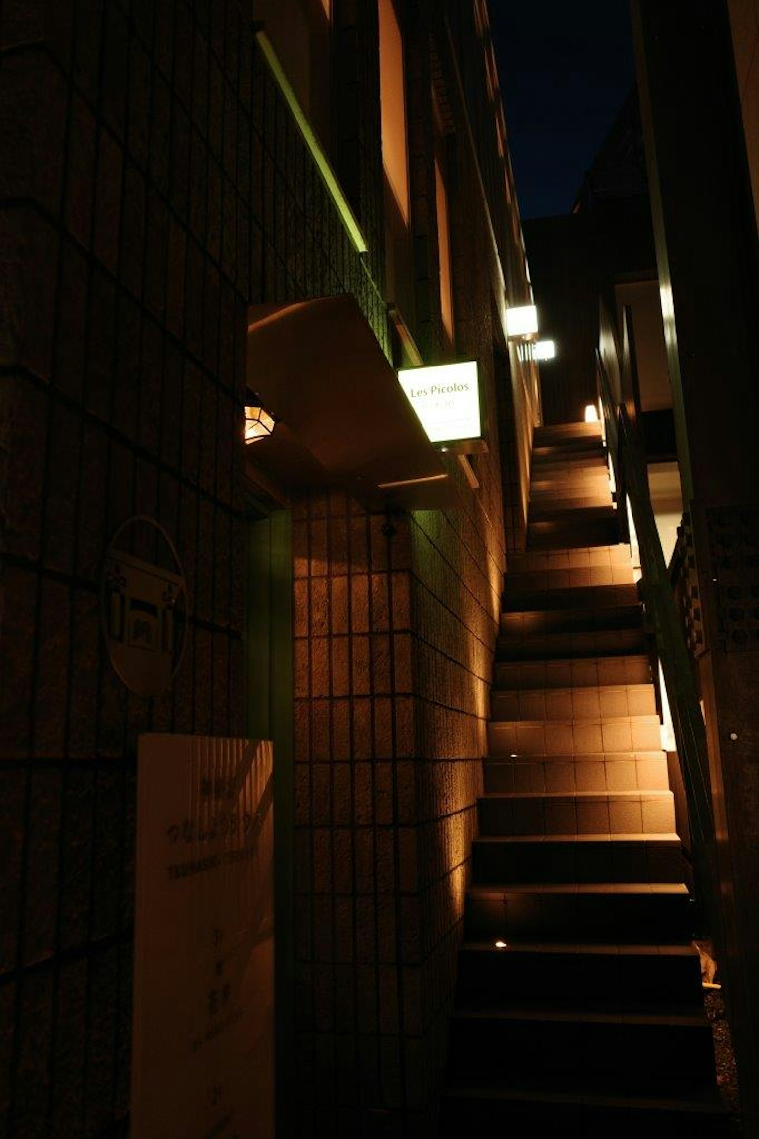 어두운 계단을 비추는 부드러운 조명과 돌 벽