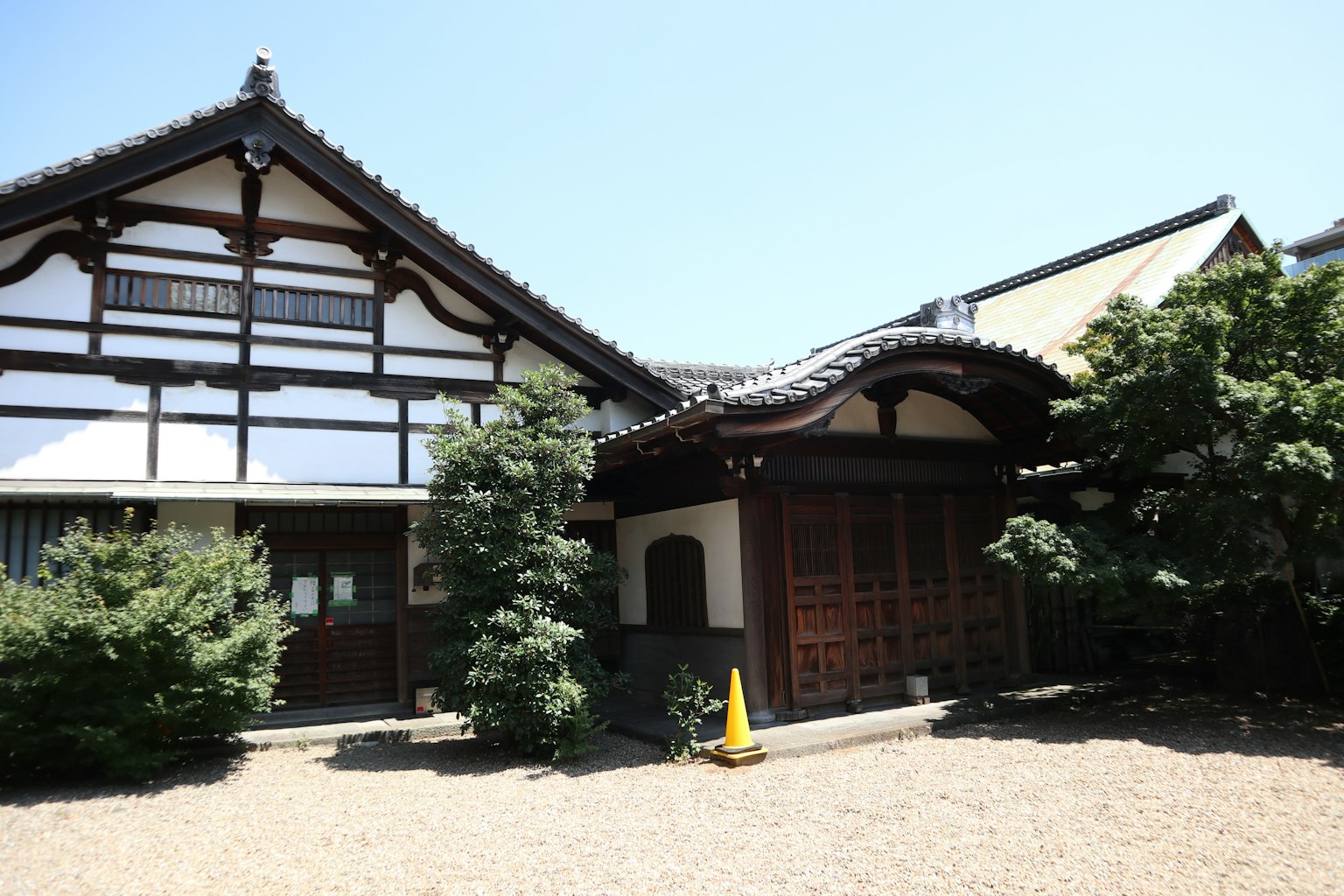 傳統日本房屋外觀，木門和花園在藍天之下