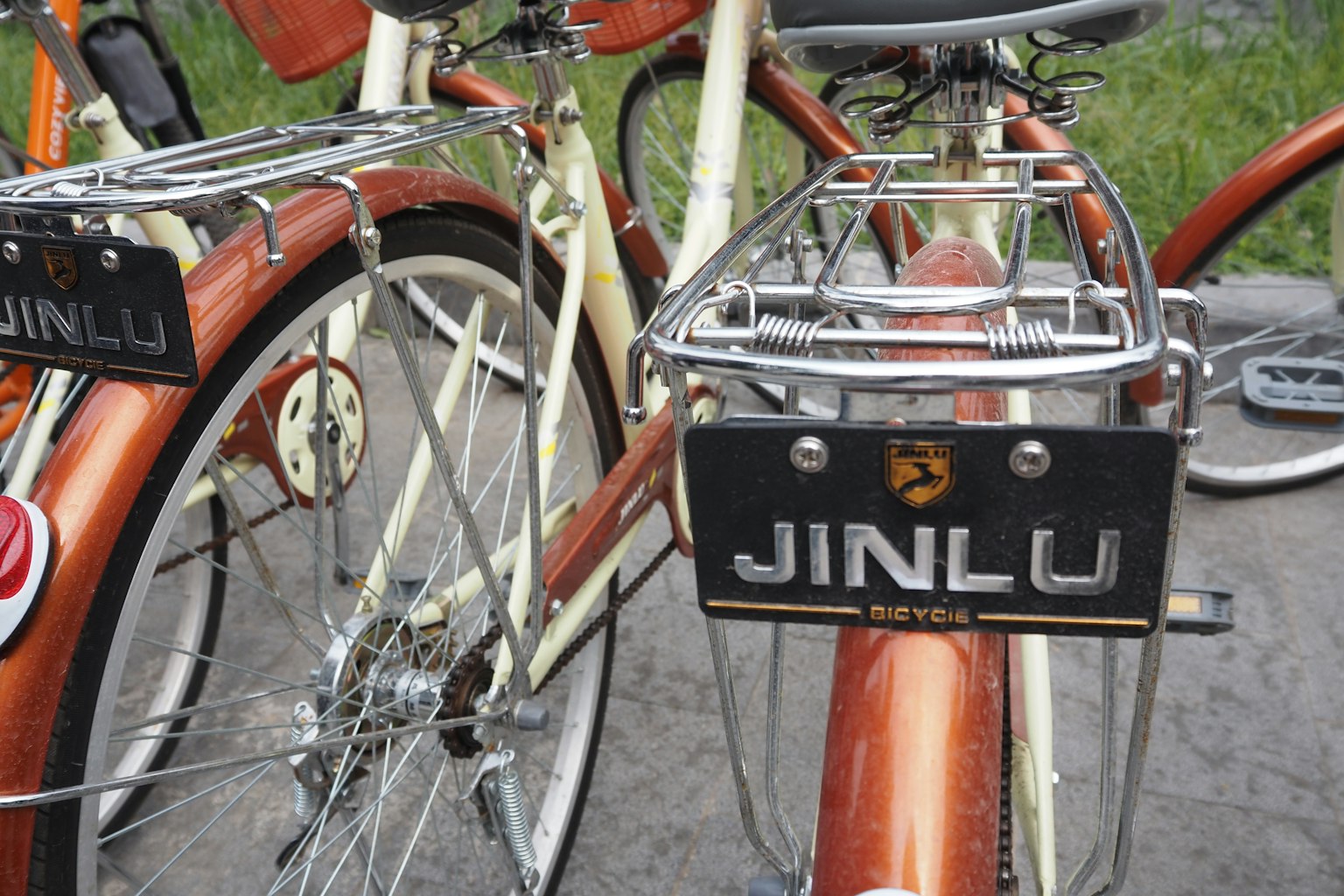 Telaio di bicicletta marrone con una placca nera che riporta JINLU