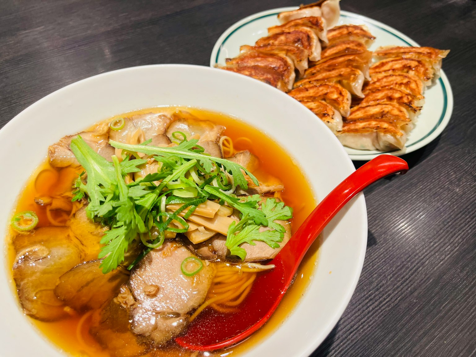 Delicious bowl of ramen with pork and gyoza on the side