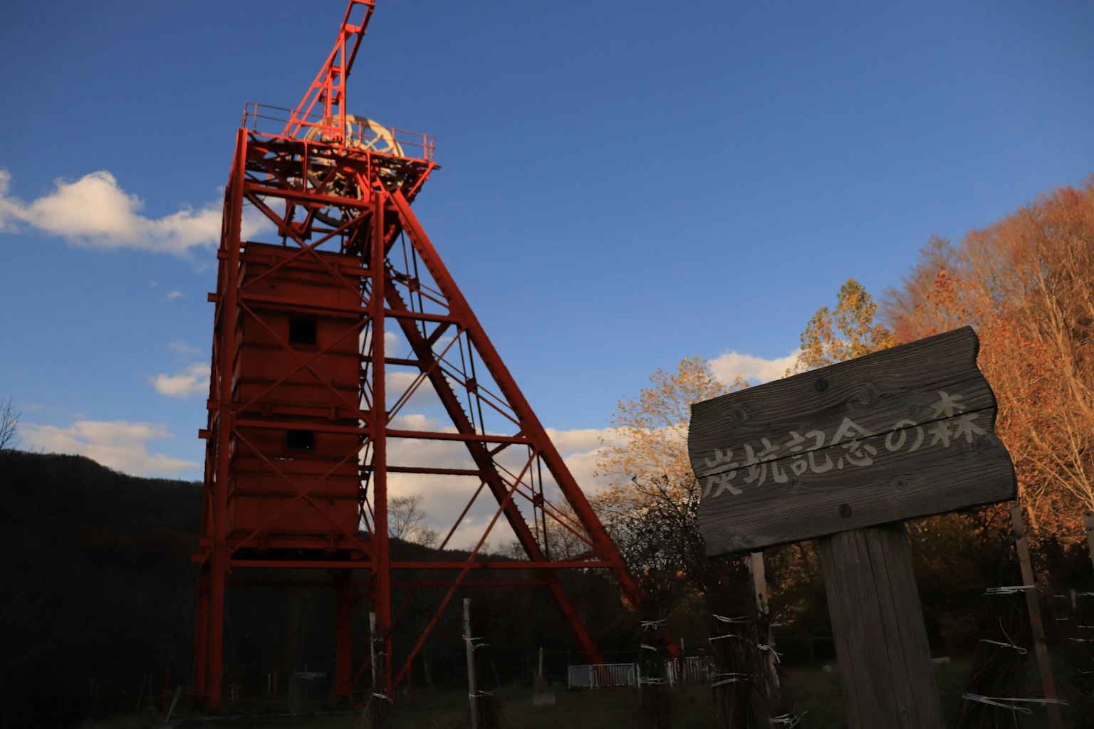 Red tower and commemorative sign in a scenic landscape