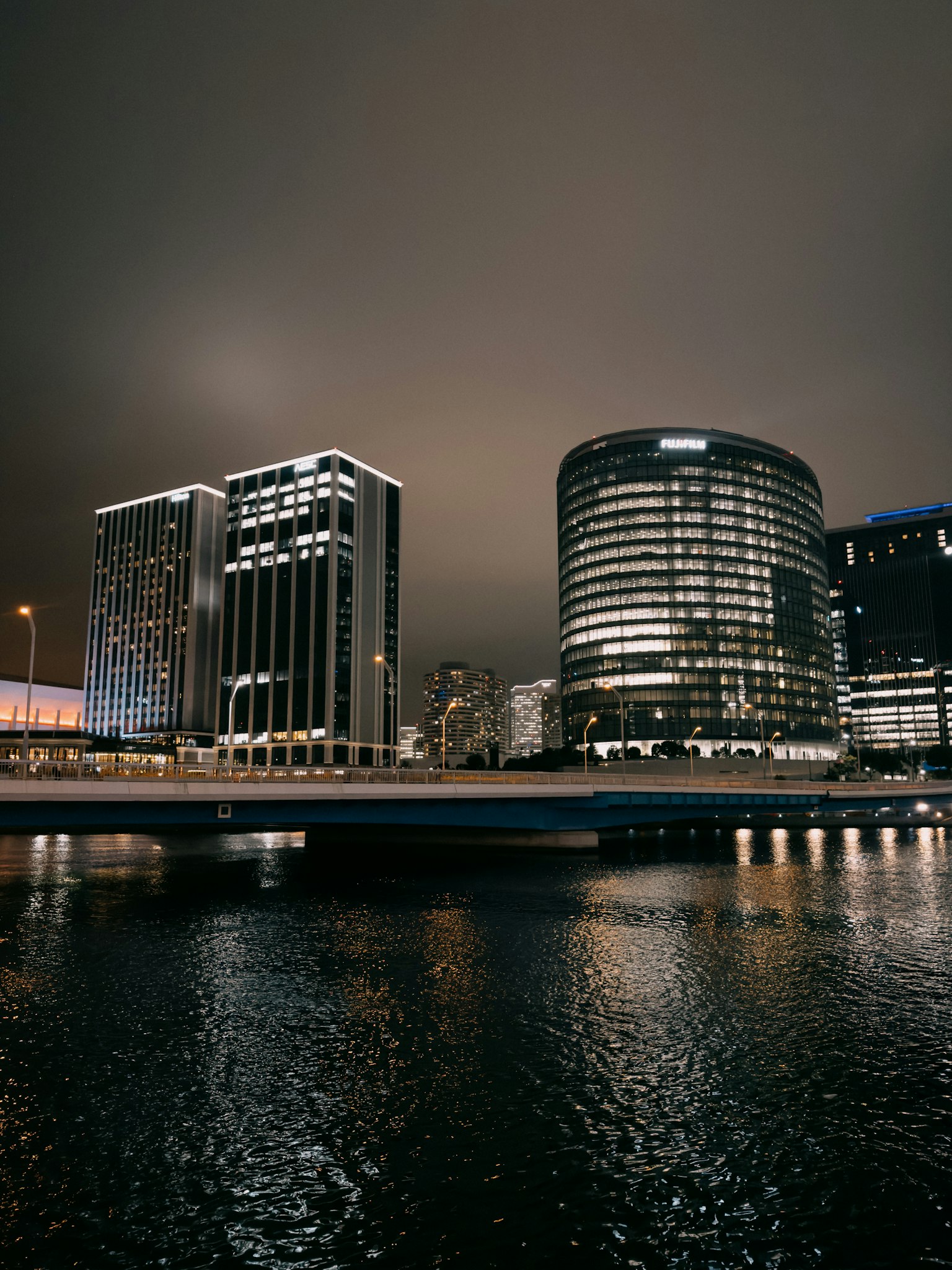Vista notturna di edifici urbani con riflessi sull'acqua