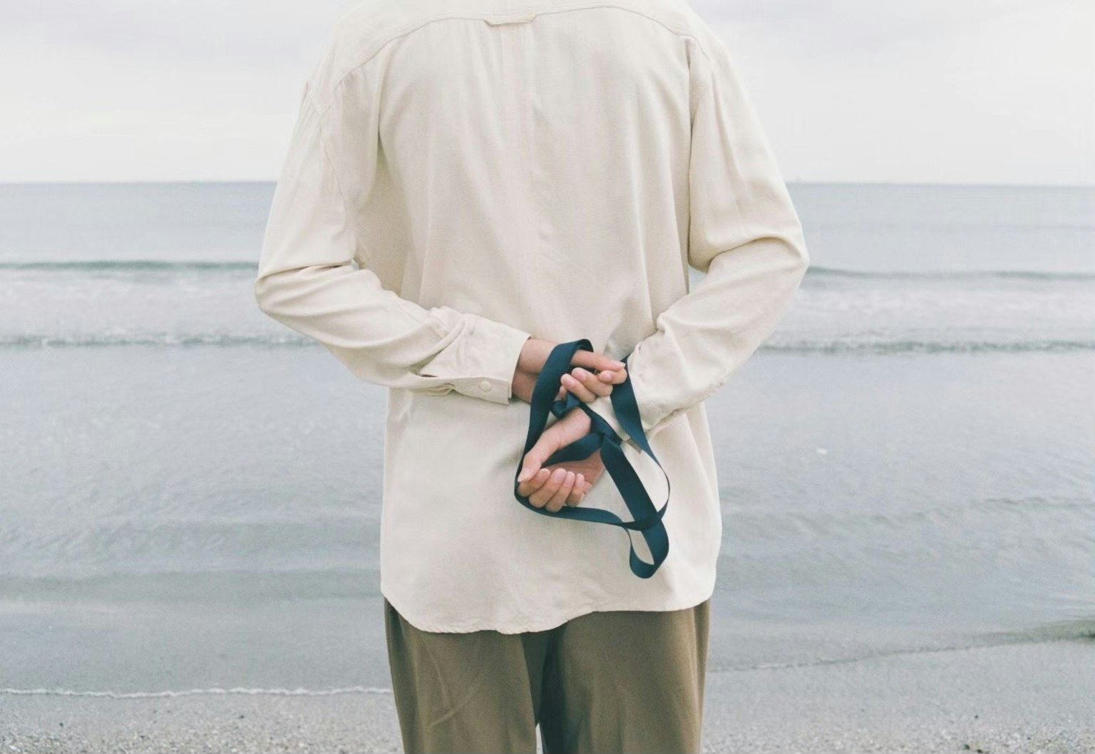 海灘上站著的人把牽引帶放在背後