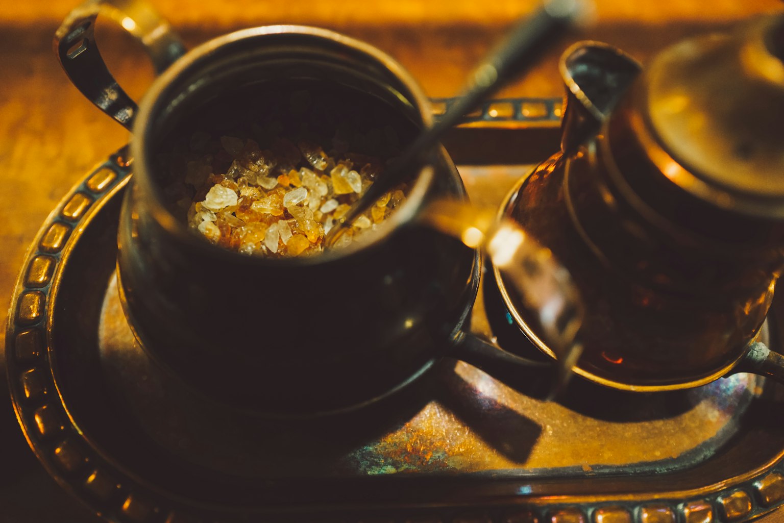 円形の金属のトレーの上に置かれた二つのコーヒーポットとその中のコーヒー豆