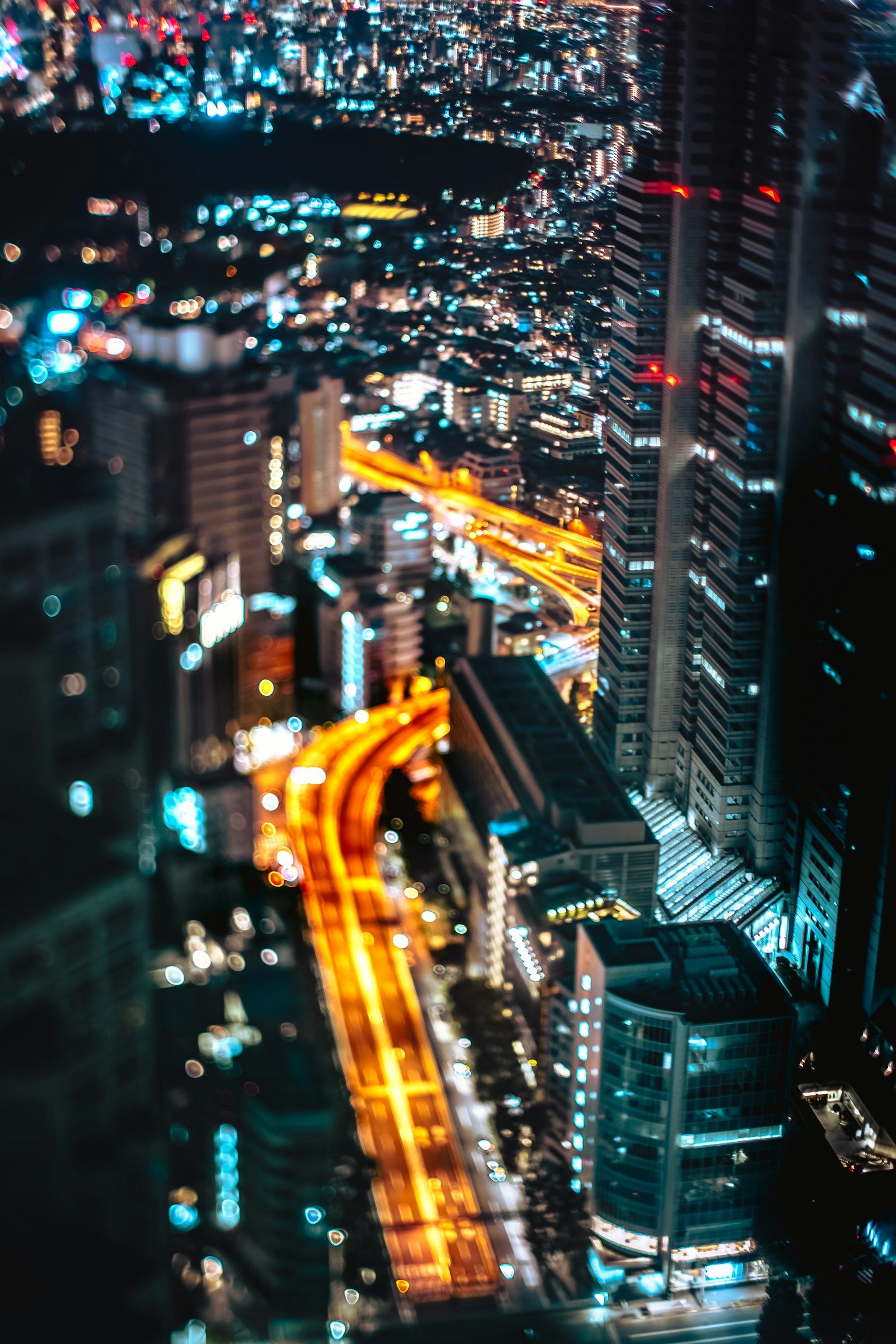 Vue aérienne d'une ville vibrante la nuit avec des routes illuminées et des gratte-ciels