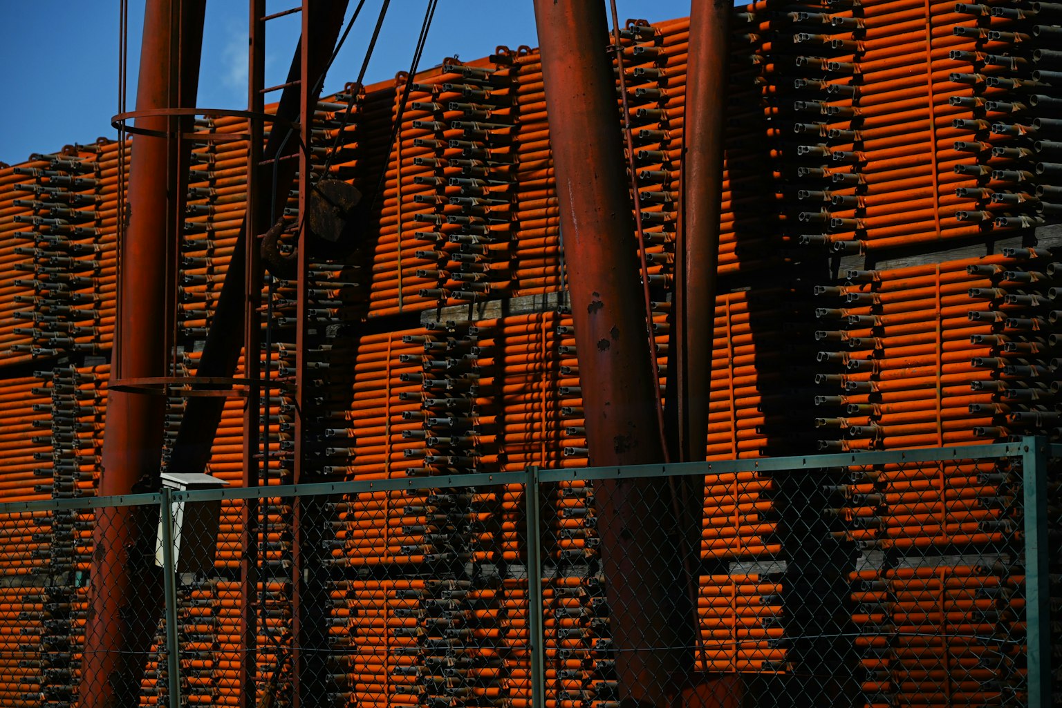 Materiali da costruzione impilati in arancione con strutture metalliche