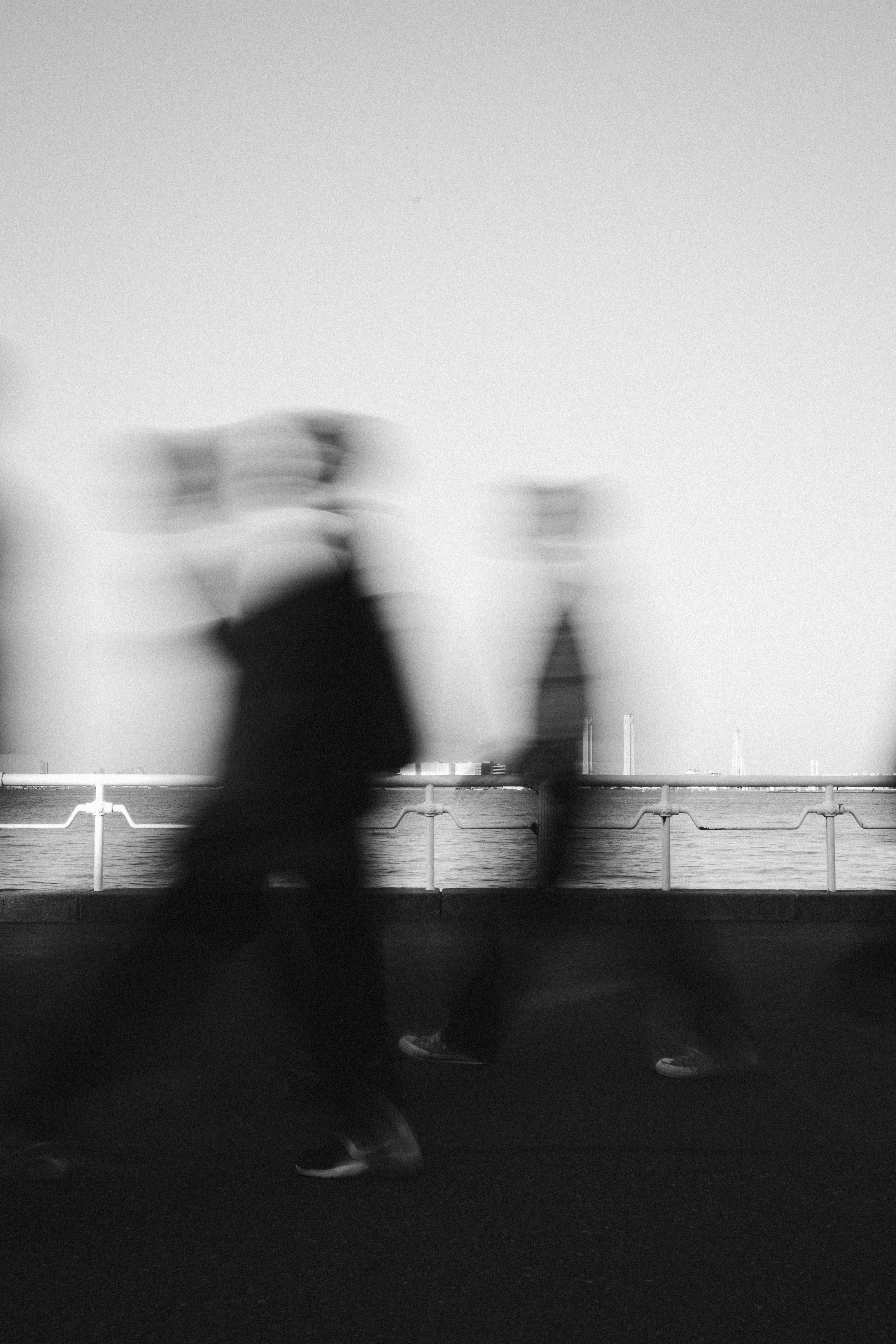 Schwarzweiße Silhouetten von Menschen, die durch den Yamashita-Park gehen