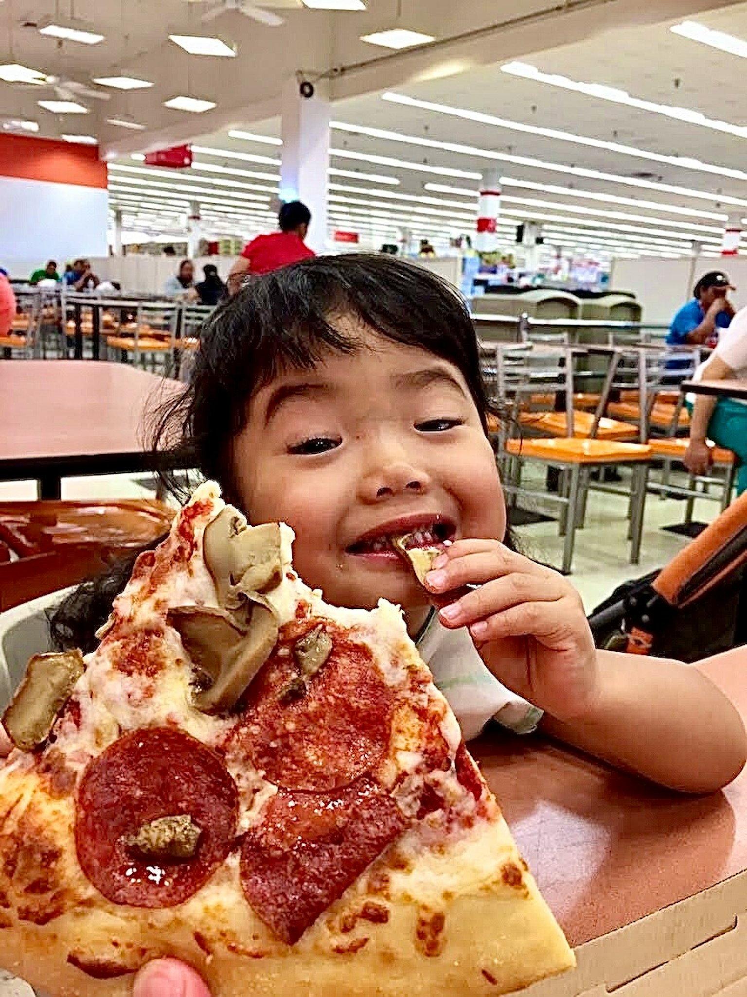 Un bambino che gusta una fetta di pizza con un'espressione felice