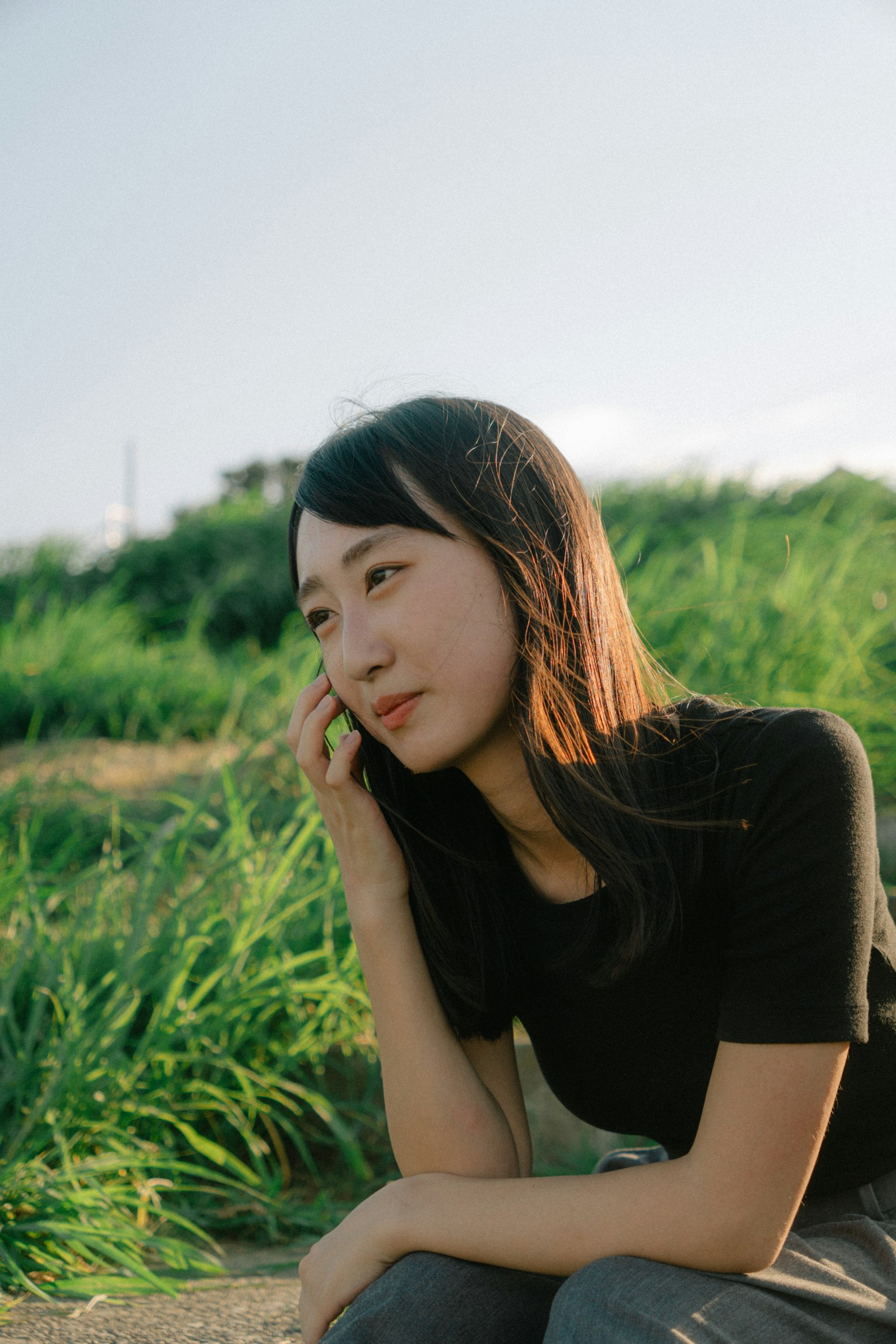 一位女性在草地上打電話