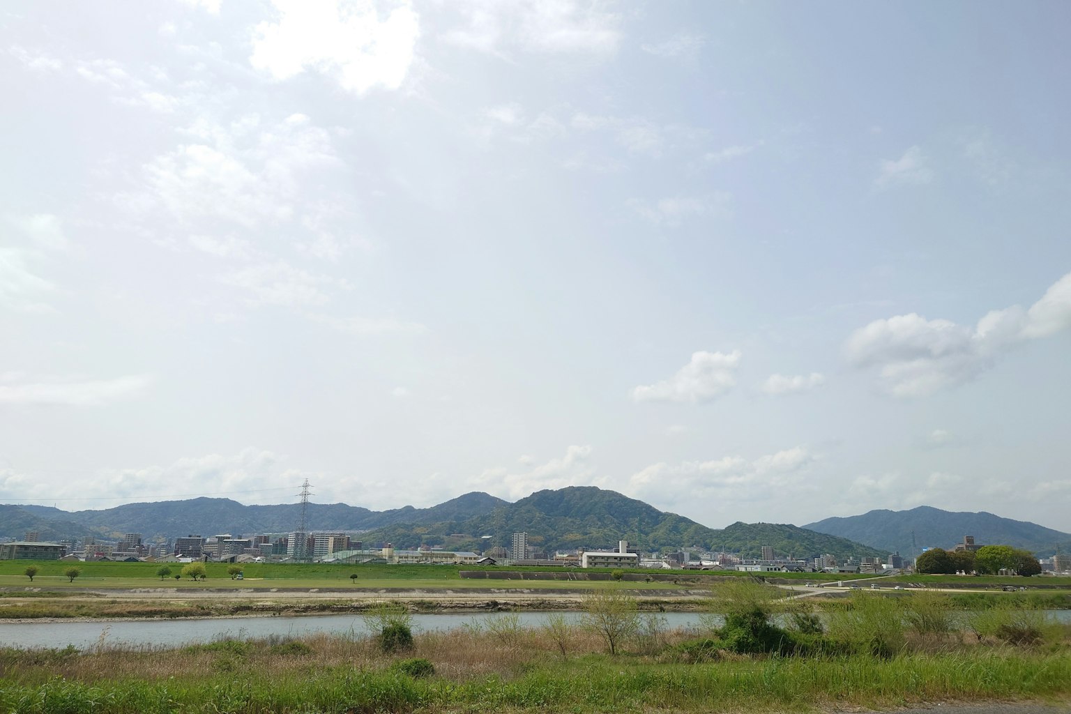 Scenic view with blue sky and mountains featuring fields and a river