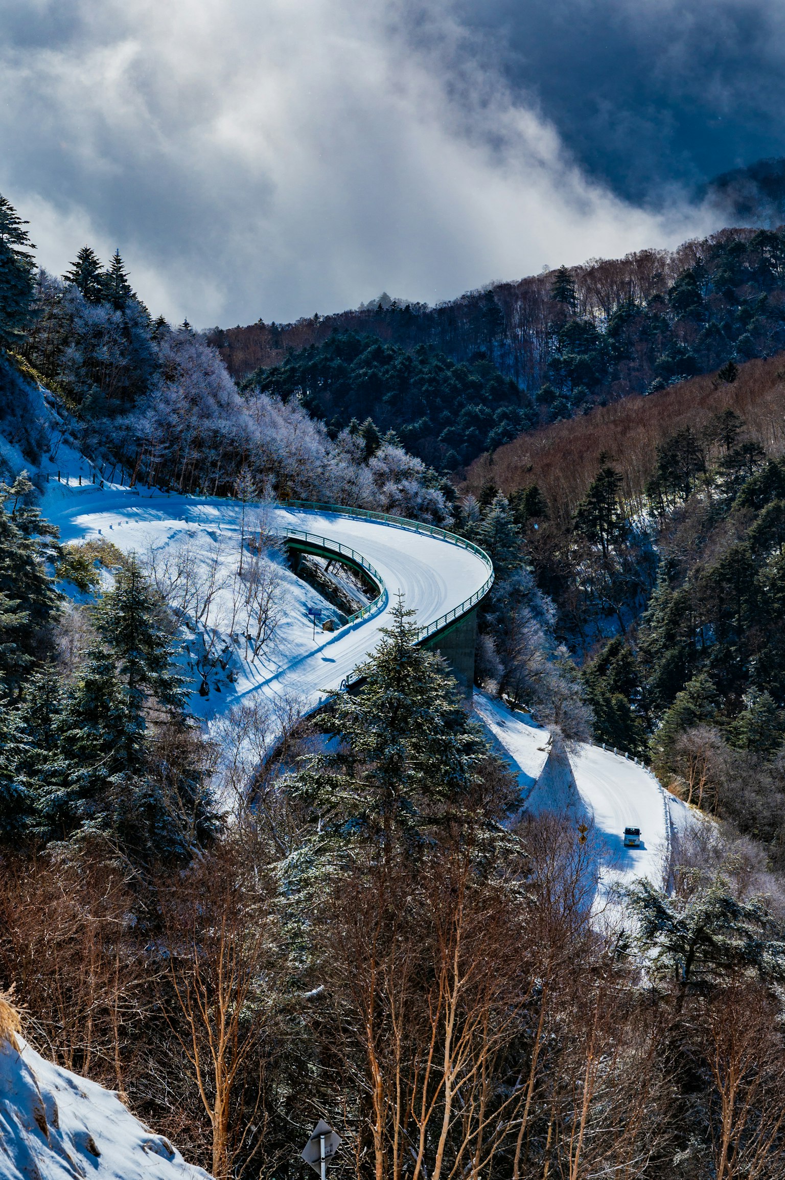 蜿蜒的雪-covered山路被森林和风景如画的冬季景观环绕