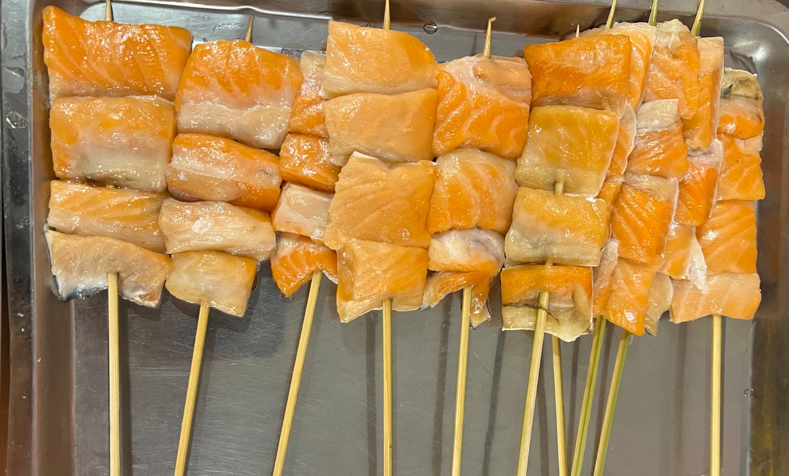 꼬치에 꽂힌 연어 조각이 깔끔하게 배열되어 있다