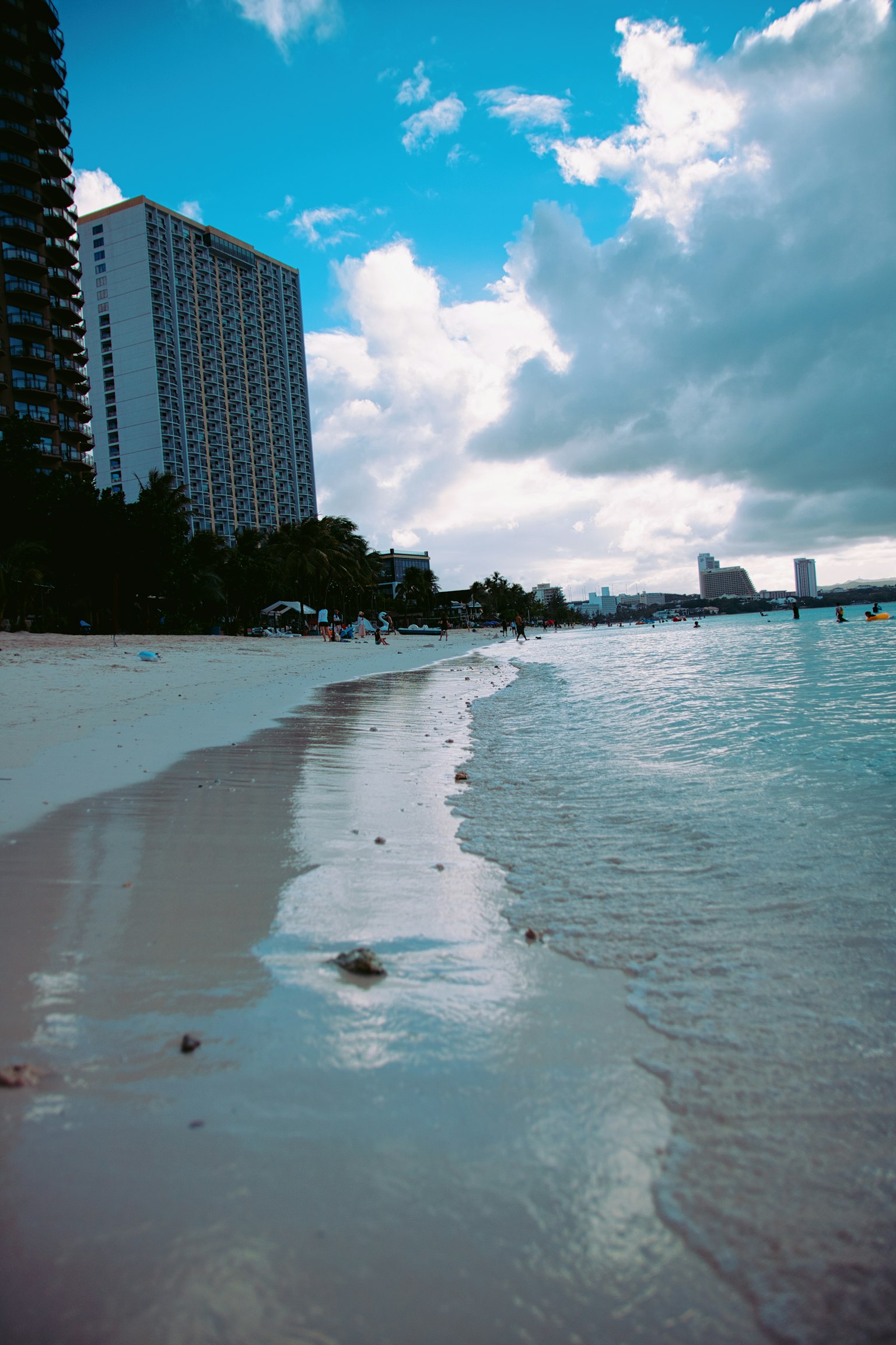 海滩风景，蓝天和白沙滩，背景有大型建筑