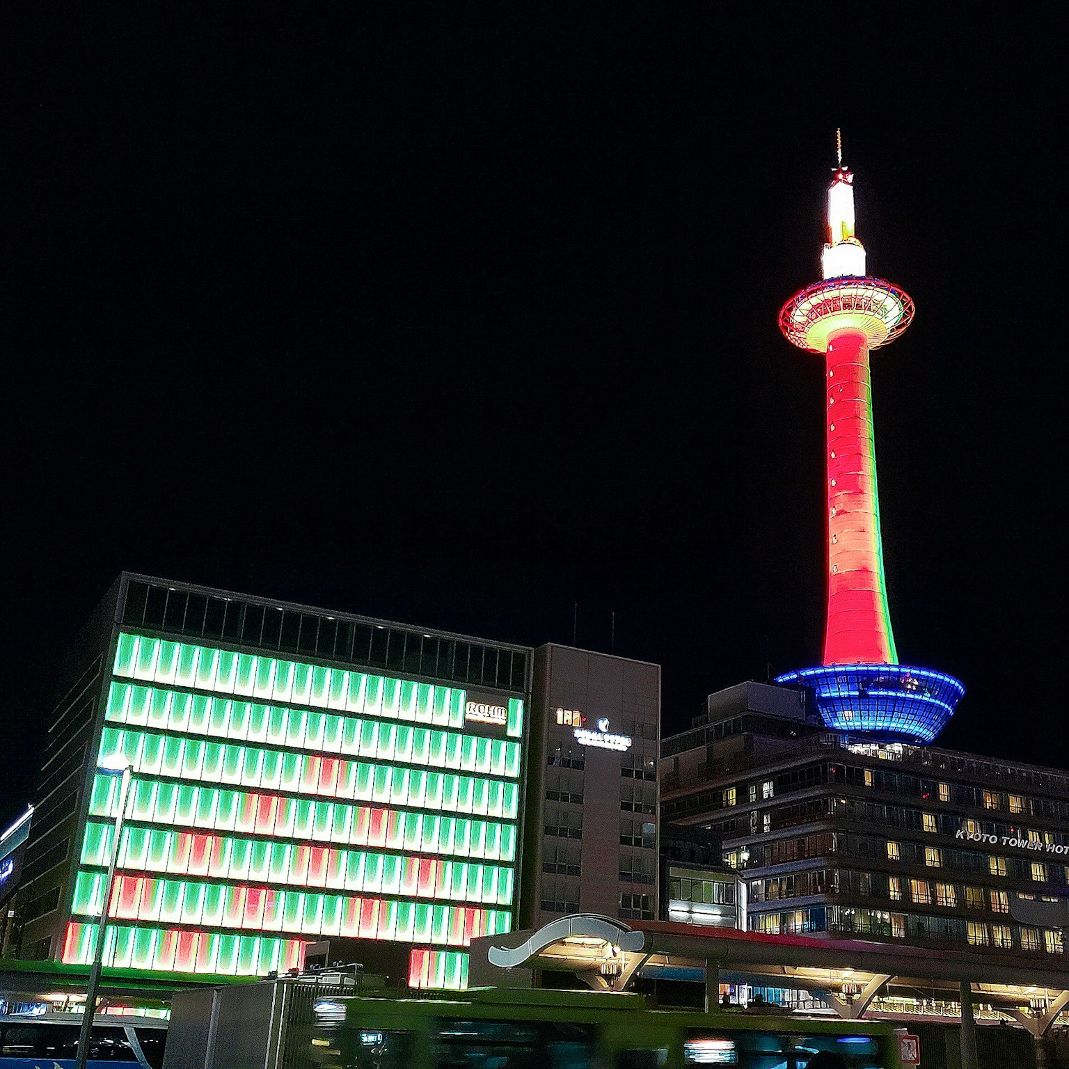Torre de Kioto iluminada por la noche con edificio colorido