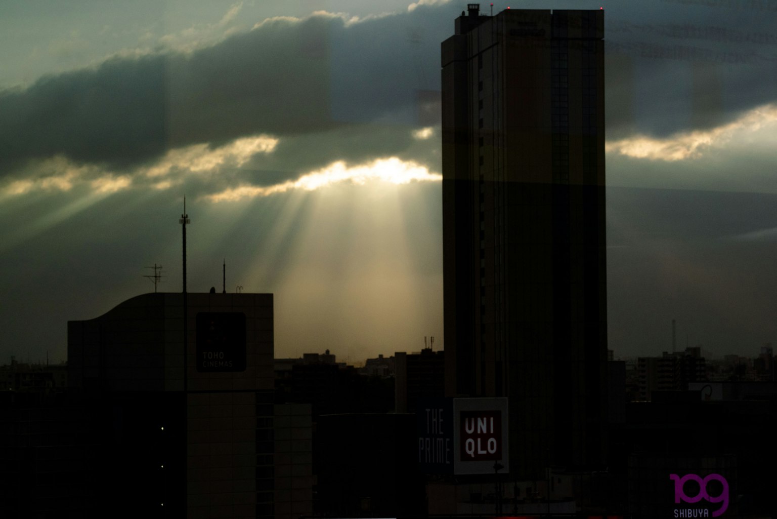 Orizzonte urbano al crepuscolo con un grattacielo e raggi di luce